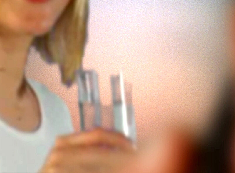 Blurry image of a person holding a transparent object. 