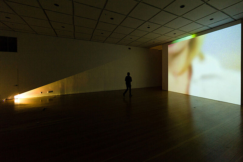 Installation view of video projecting on a wall. 