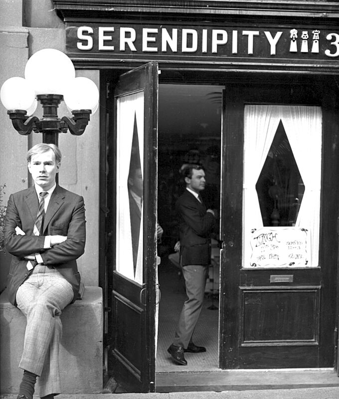 Archival photograph of Andy Warhol standing in front of Serendipity.