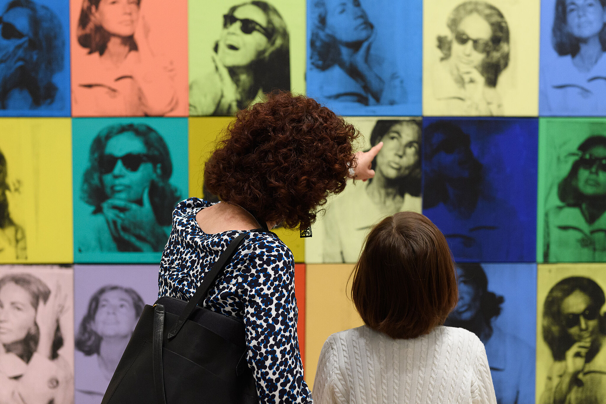 A parent and child look at Warhol's Nine Jackies.