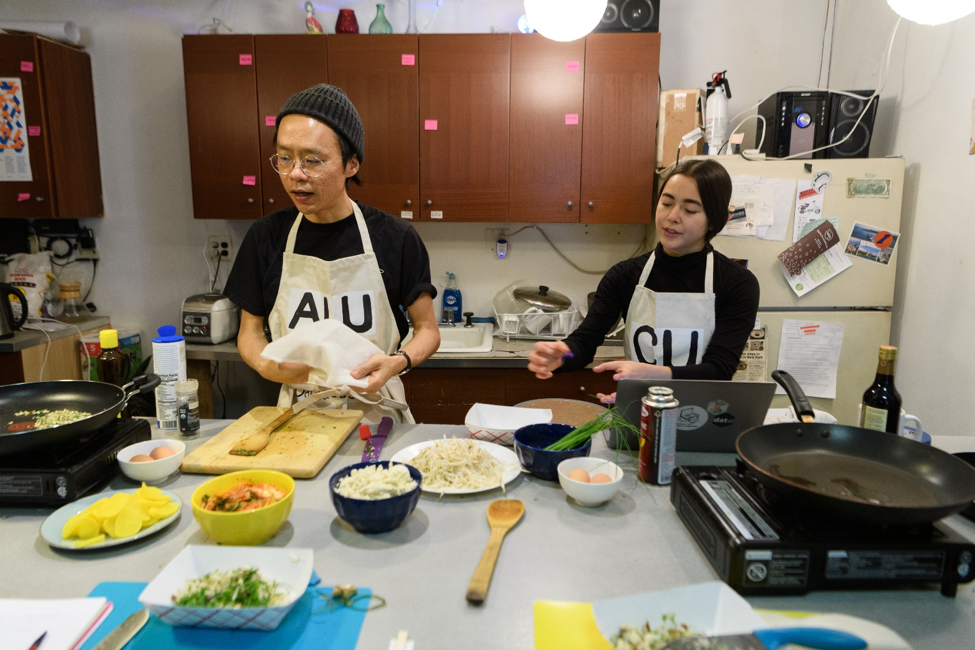 A photograph of an artist working with youth.