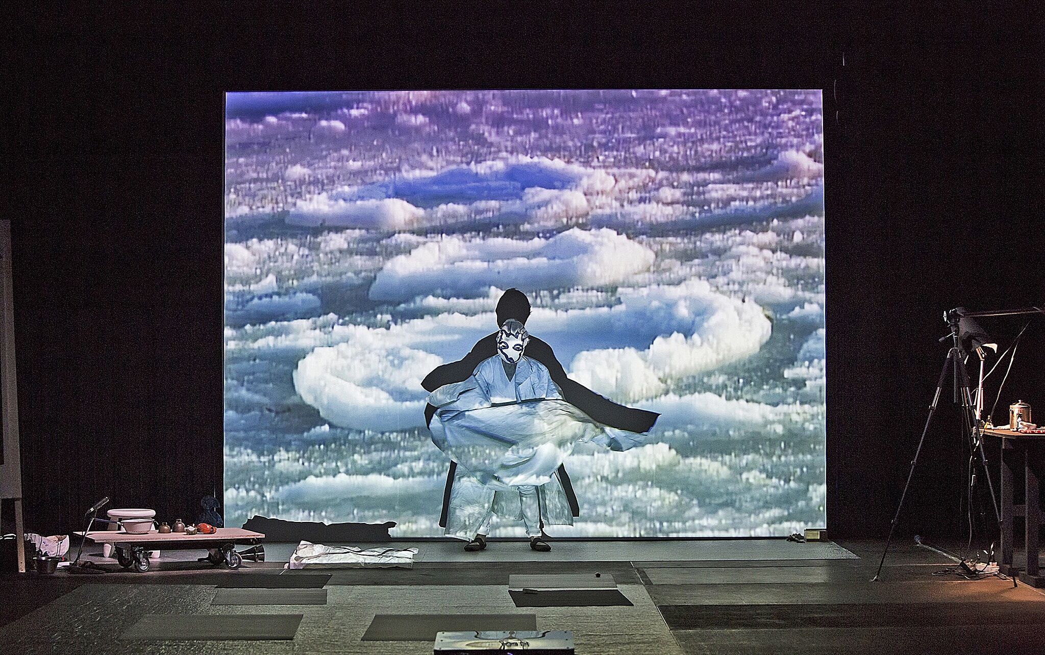 An image of a person on stage with a video being projected onto them