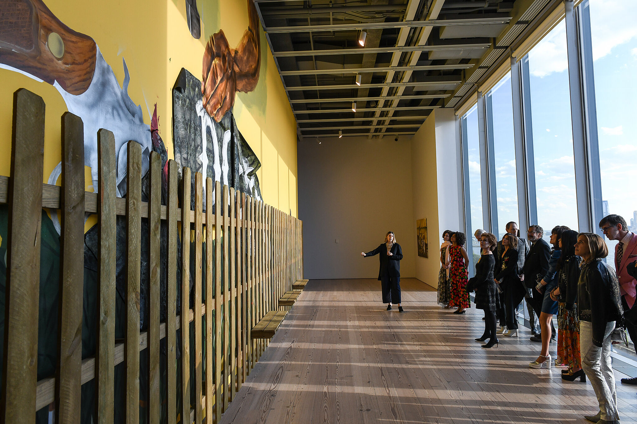 A photo of museum visitors in the gallery viewing the 2019 Whitney Biennial