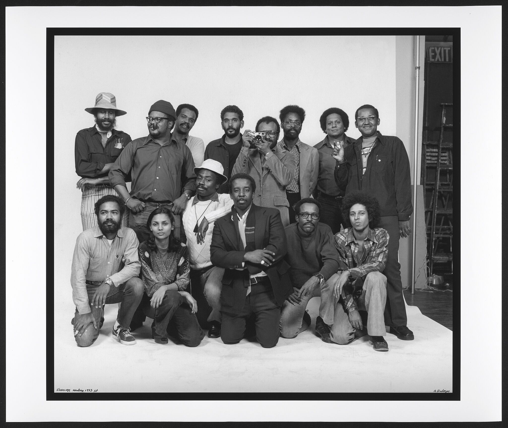 A group of African American artists who are part of the Kamoinge collective posing in front of a white backdrop.