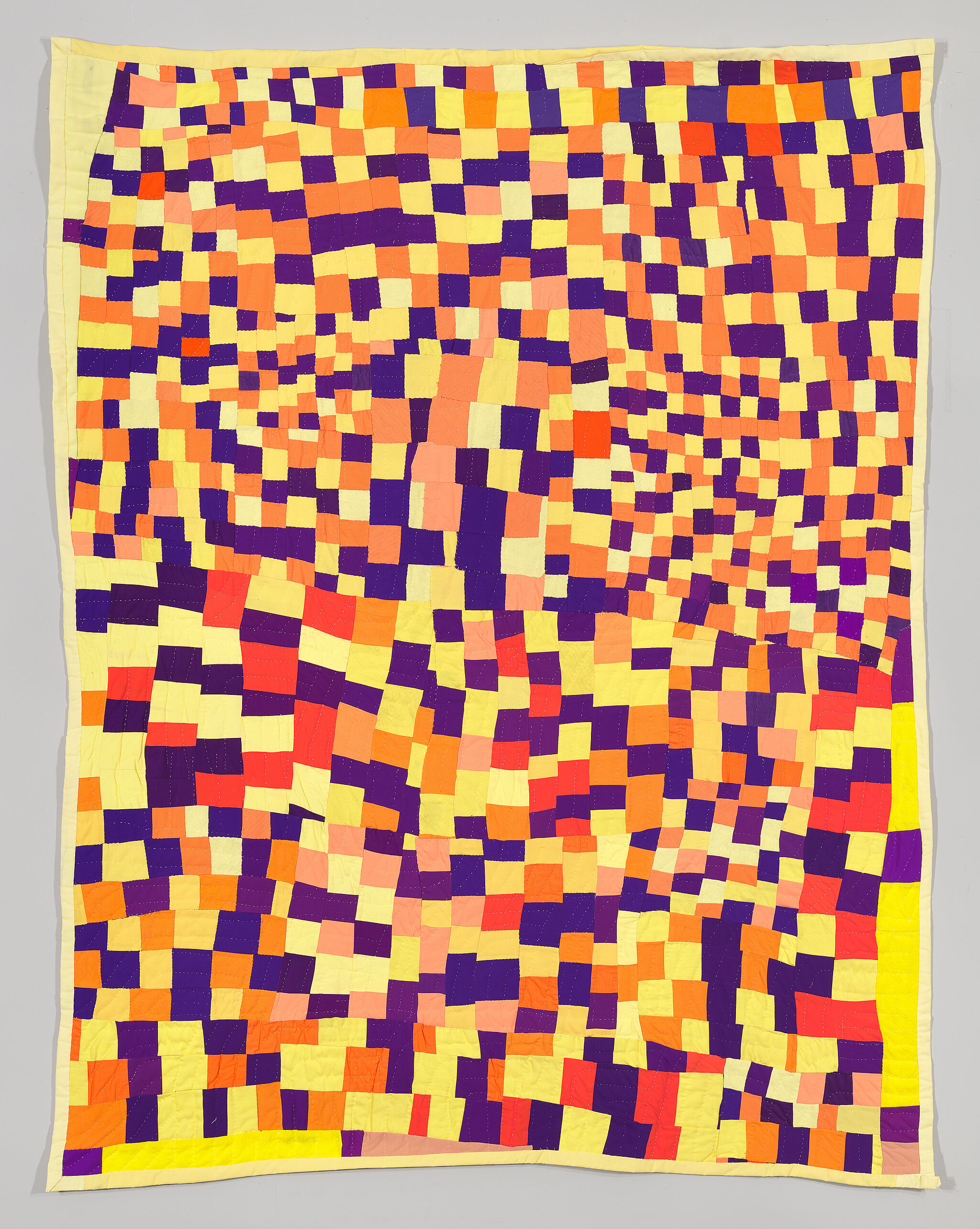A quilt composed of squares of varying sizes and colors