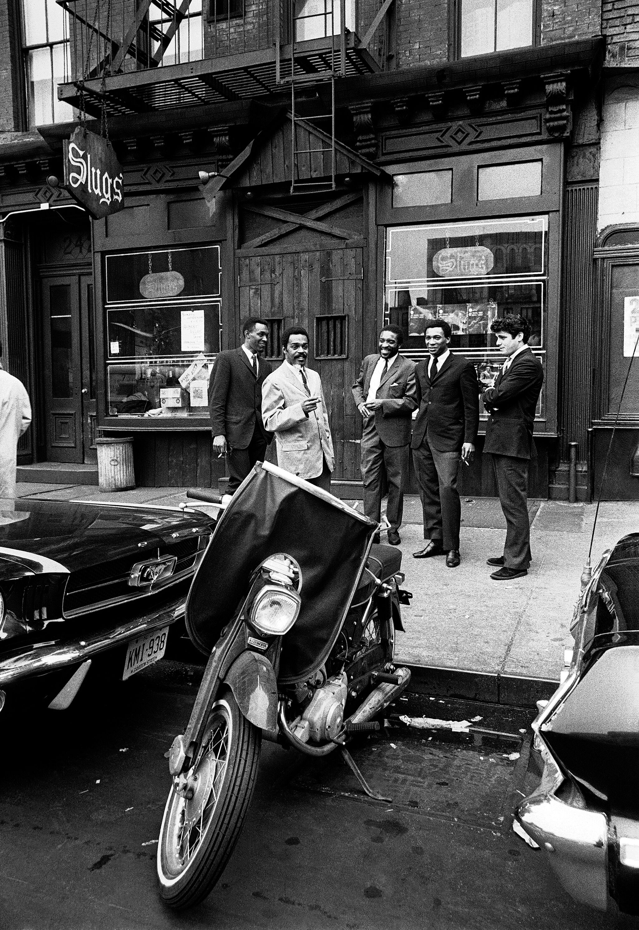 Men standing outside of Slugs' Saloon in New York City.