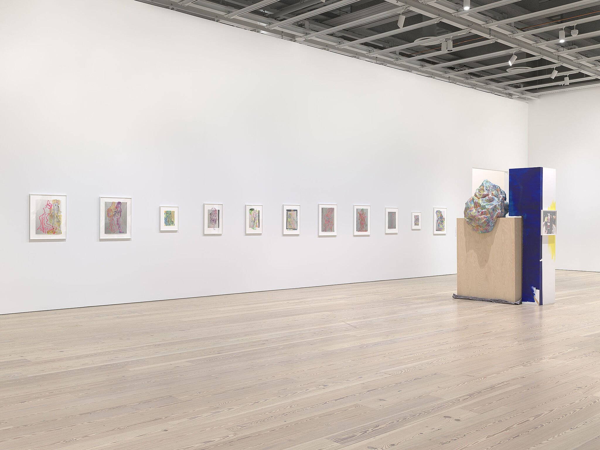 An image of the Whitney galleries with various sculptures and artworks on the walls.