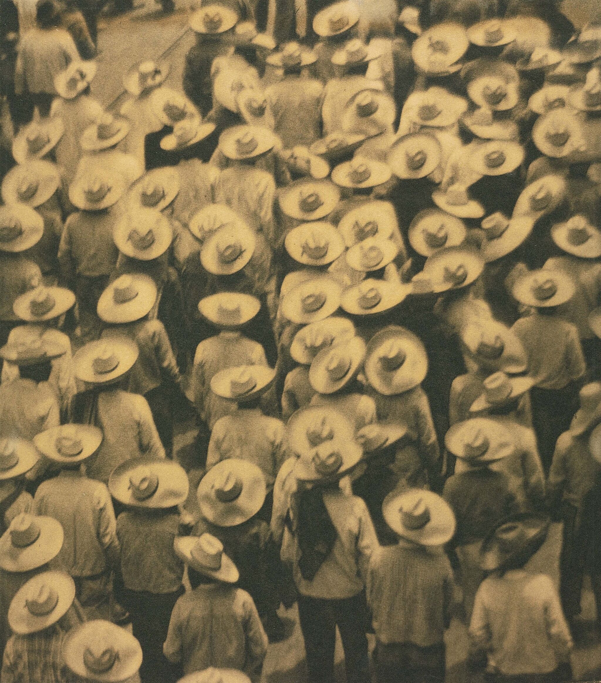 A photo from above of a crowd of people all wearing hats.