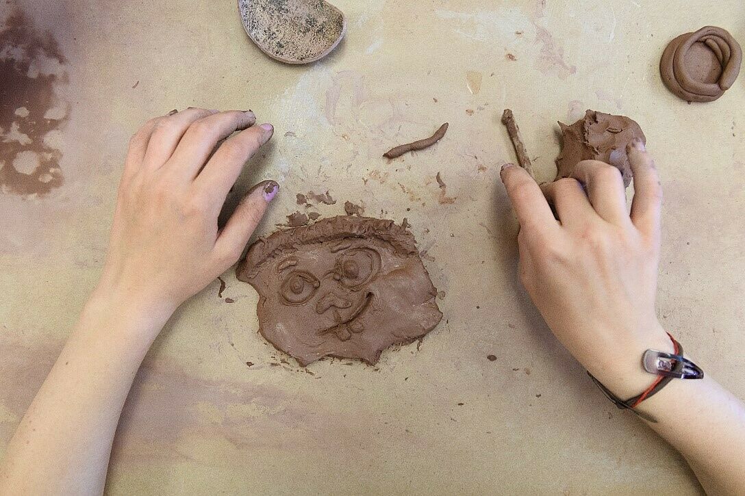A photo of a clay face being made by a child.