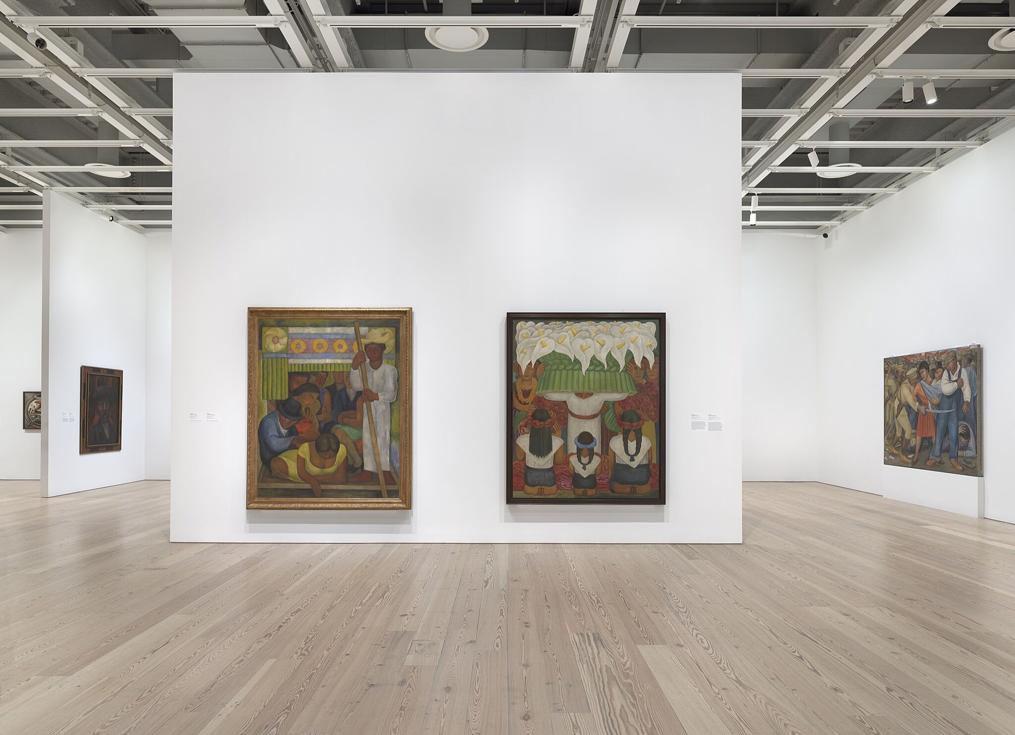 An installation photo of a gallery with large paintings.