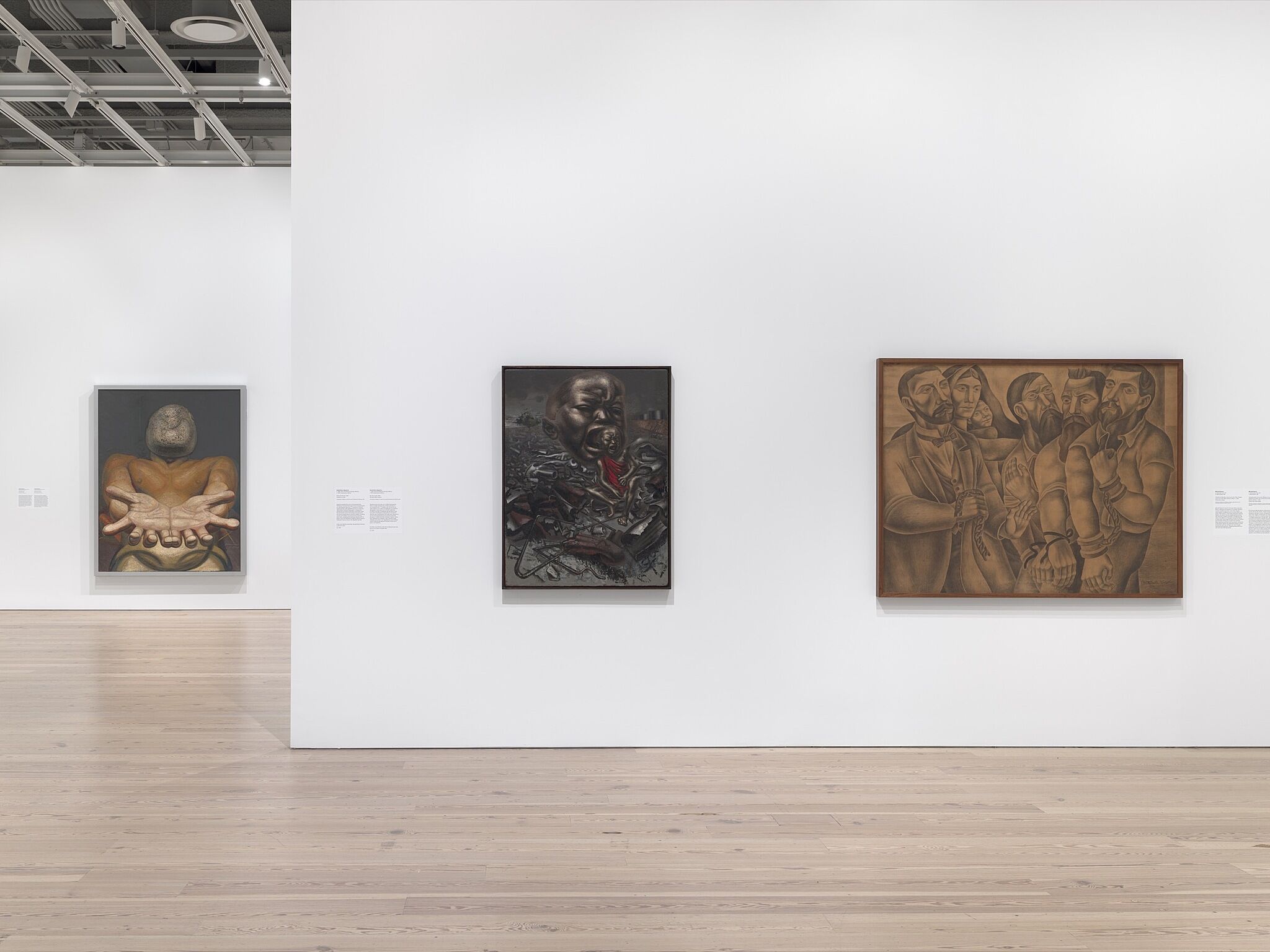 An installation photograph of a gallery with three paintings.
