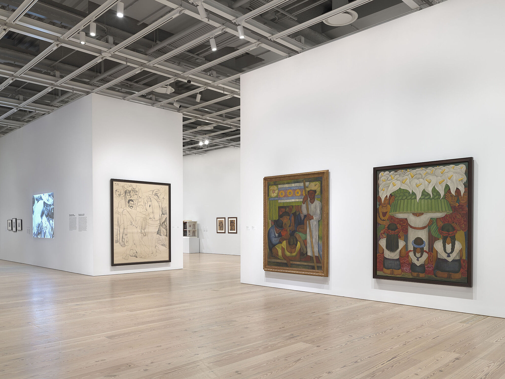 A photo of the Whitney galleries with paintings on the walls.