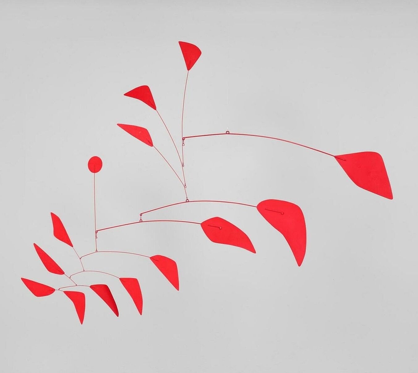Red hanging mobile on a gray background.