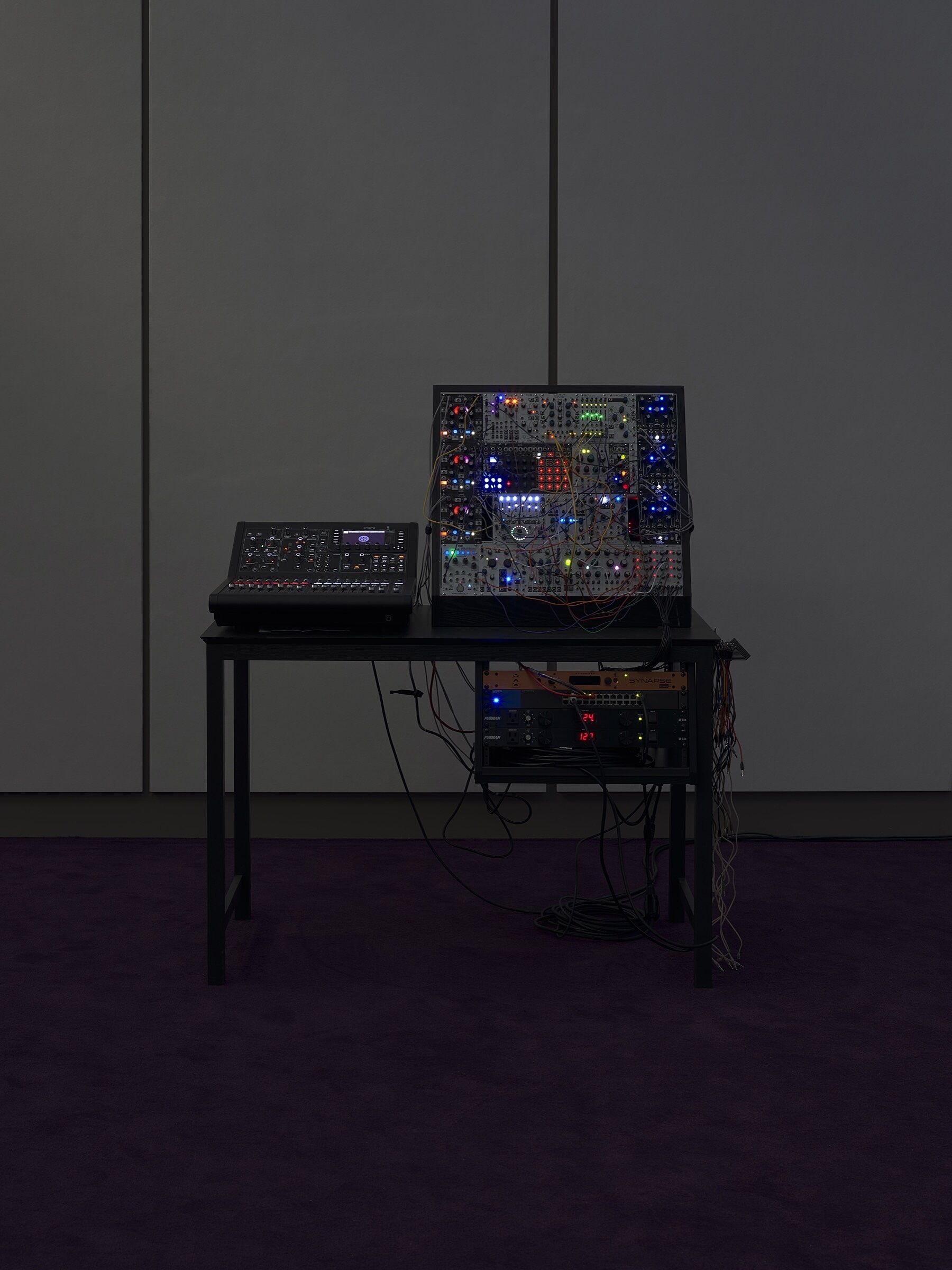 Audio equipment in a dimly lit gallery space.