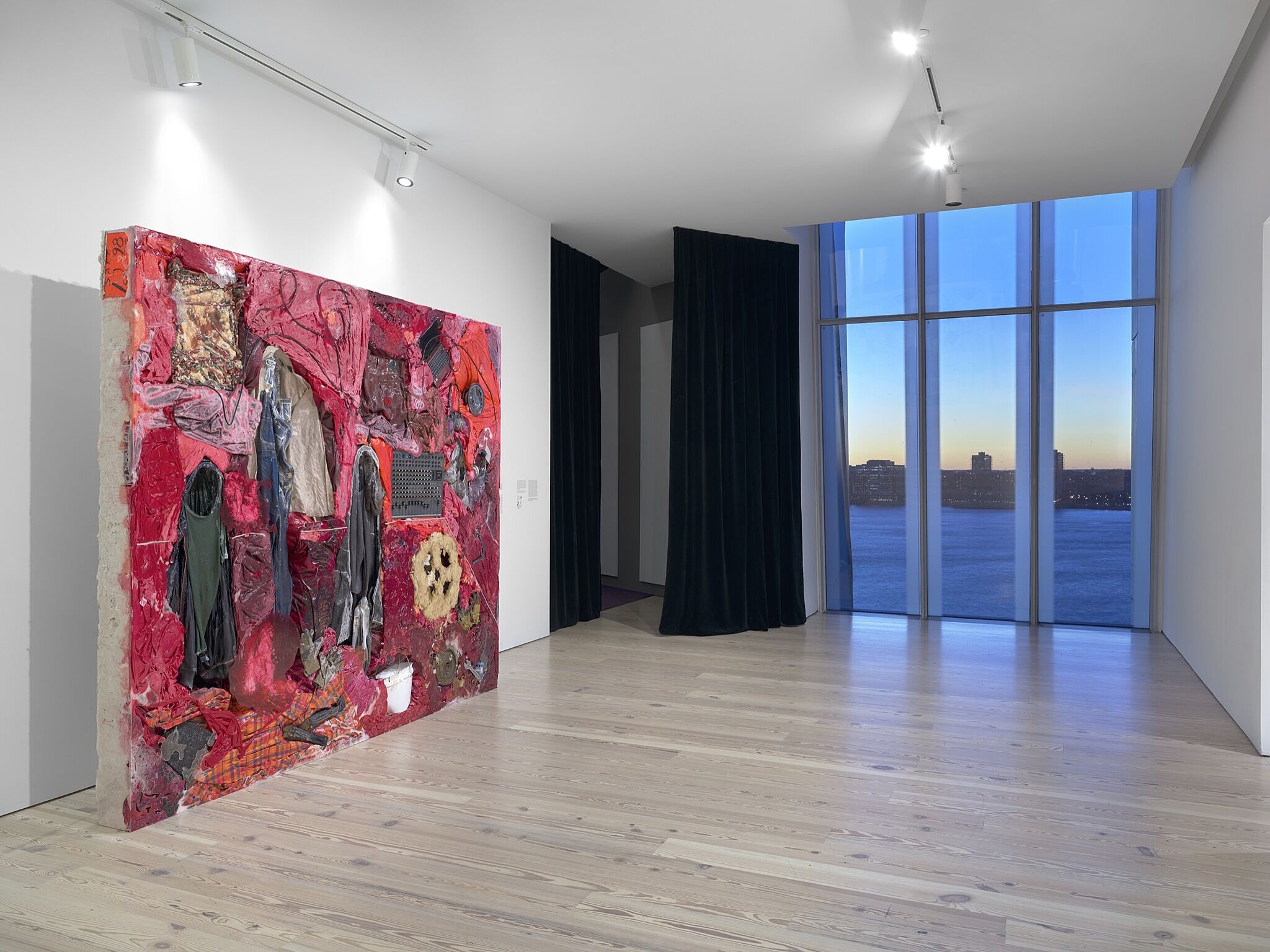 A large multi media artwork in a gallery with a window overlooking a river.