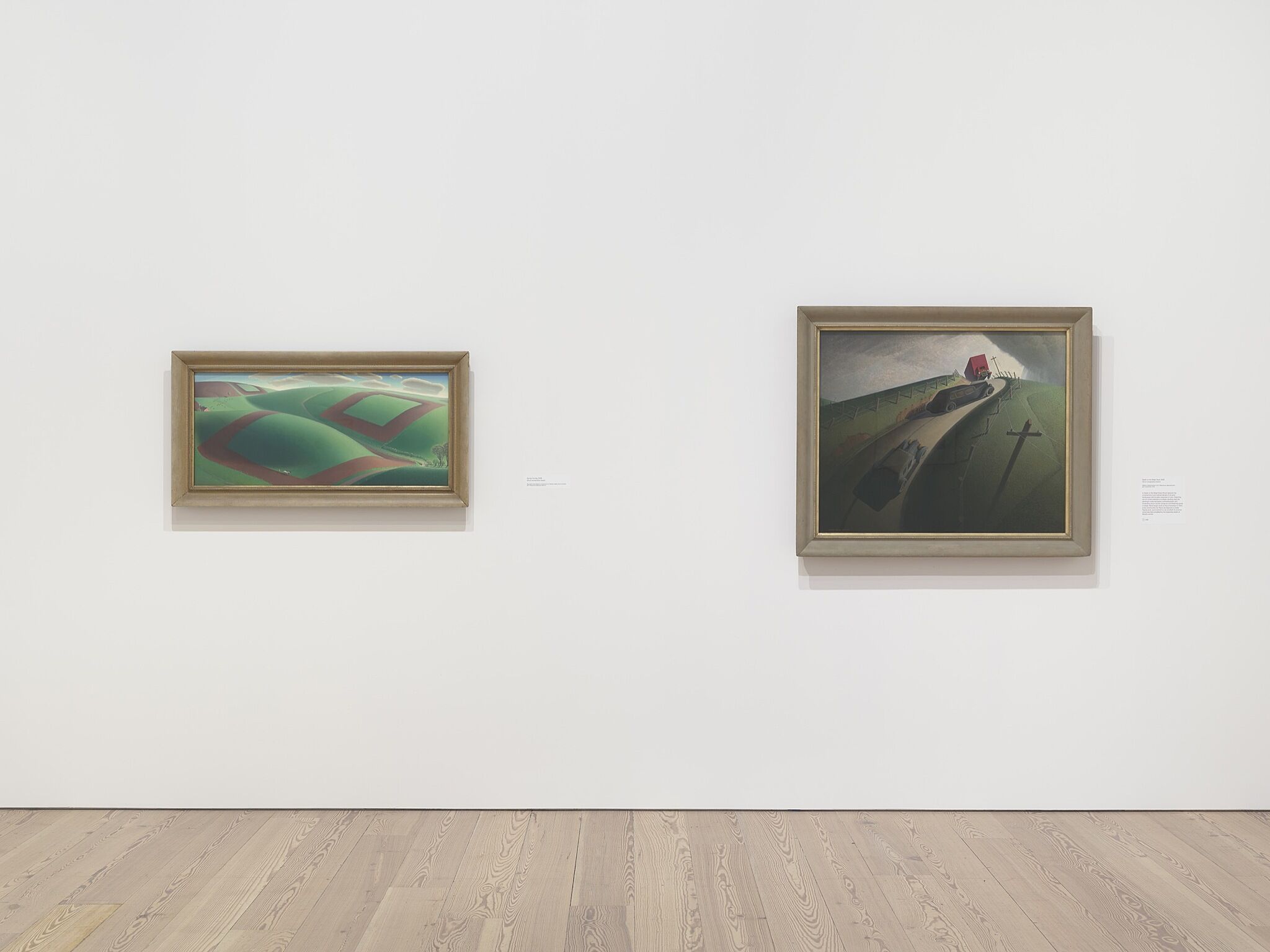 Two paintings in a white-walled gallery.