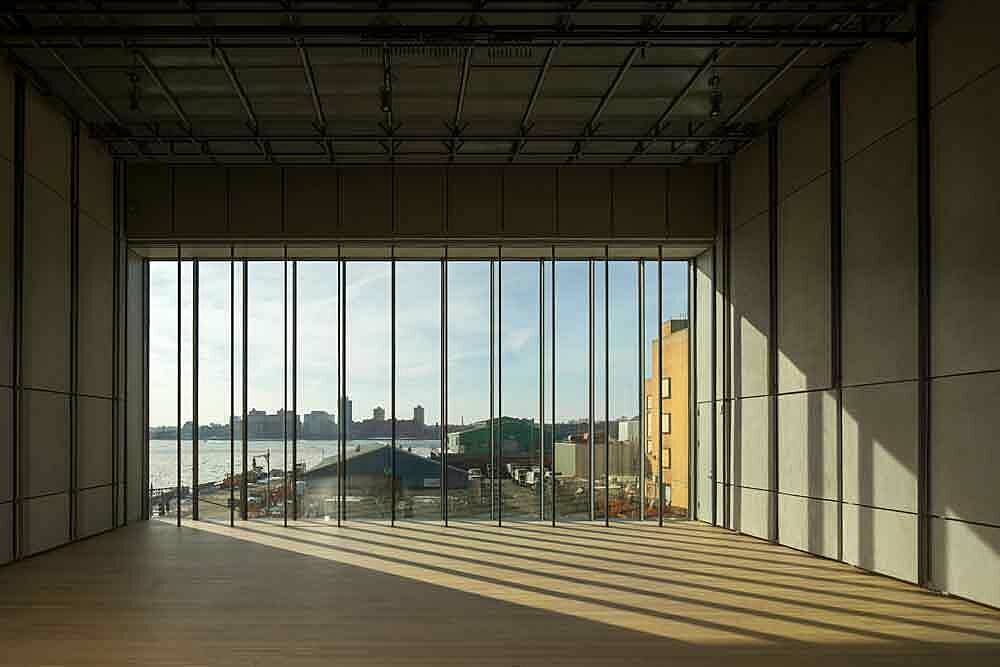 The theater of the Whitney Museum of American Art, empty with shadows and light from the large windows.