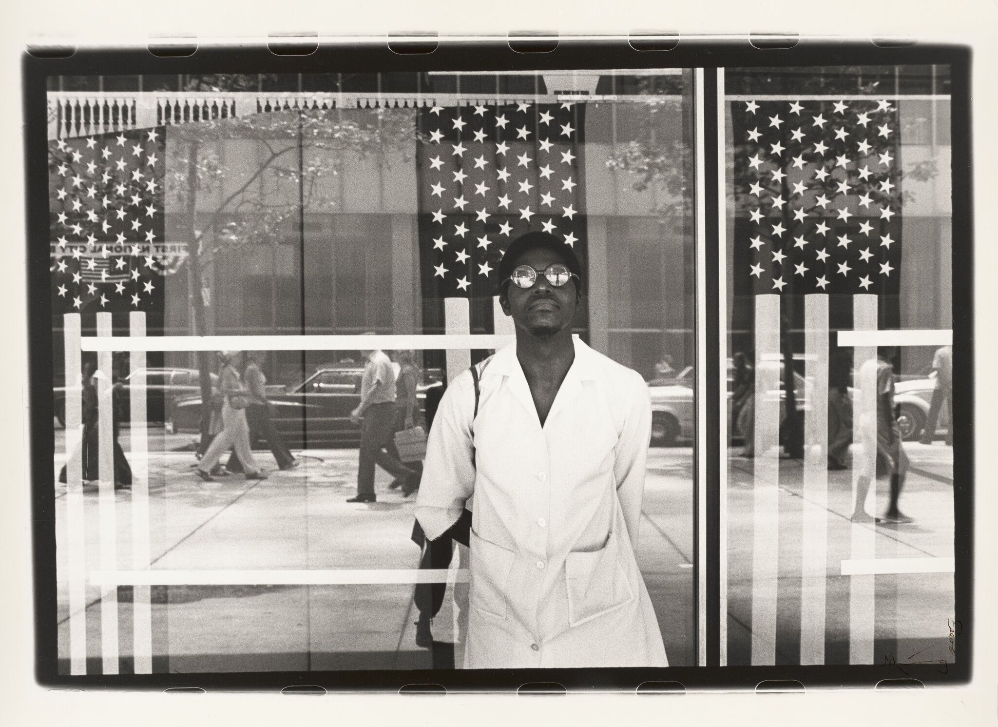 A man stands in front of American flags.
