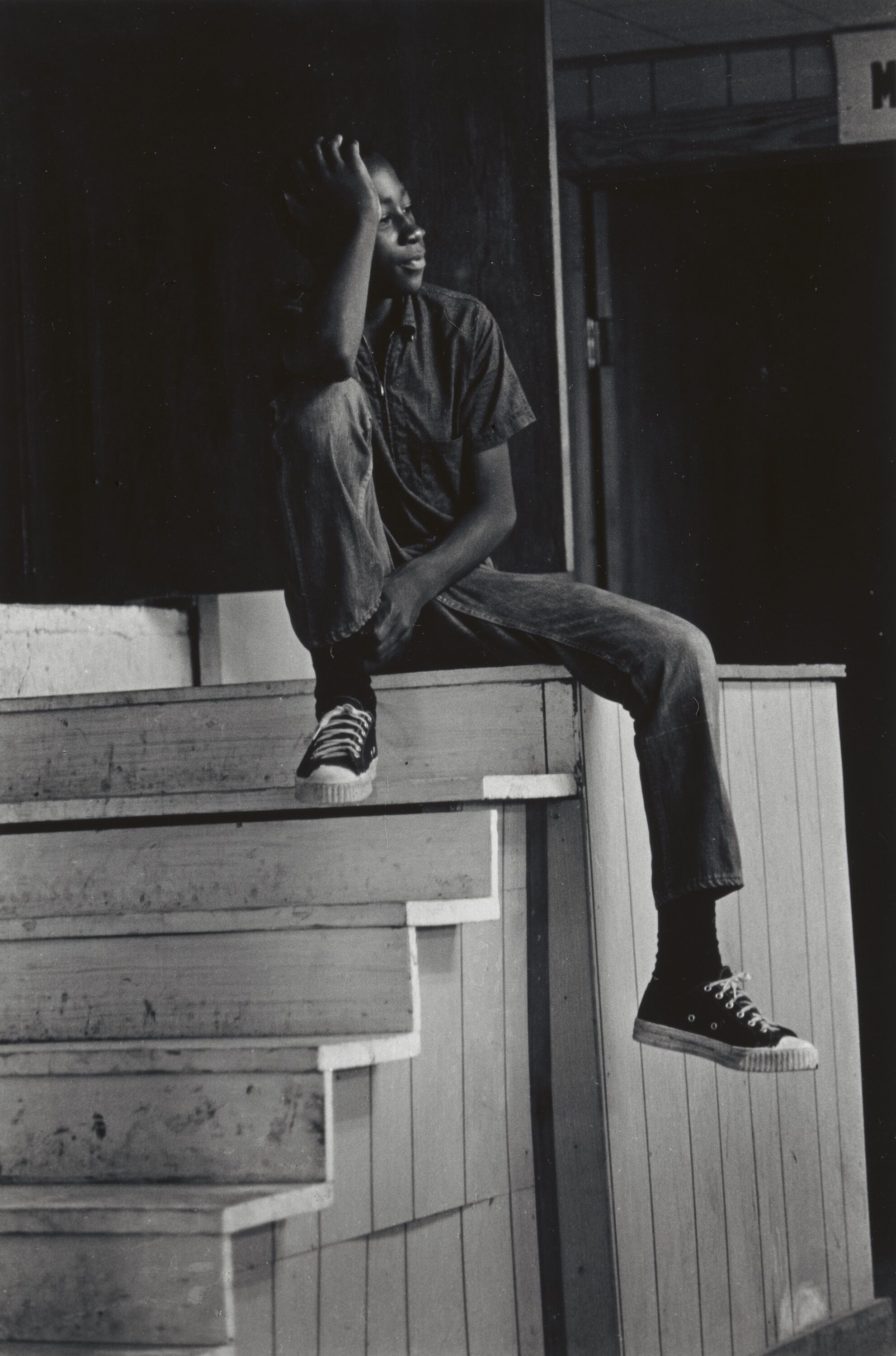 A person sitting at the top of a staircase.