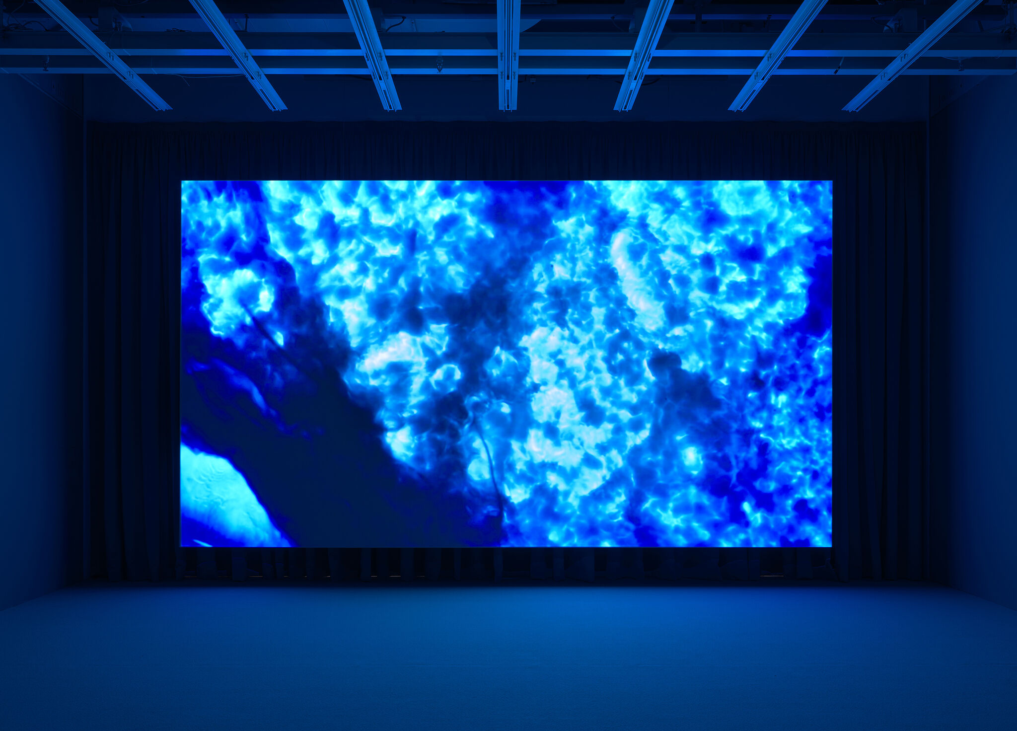 A large screen displaying a video in a gallery.