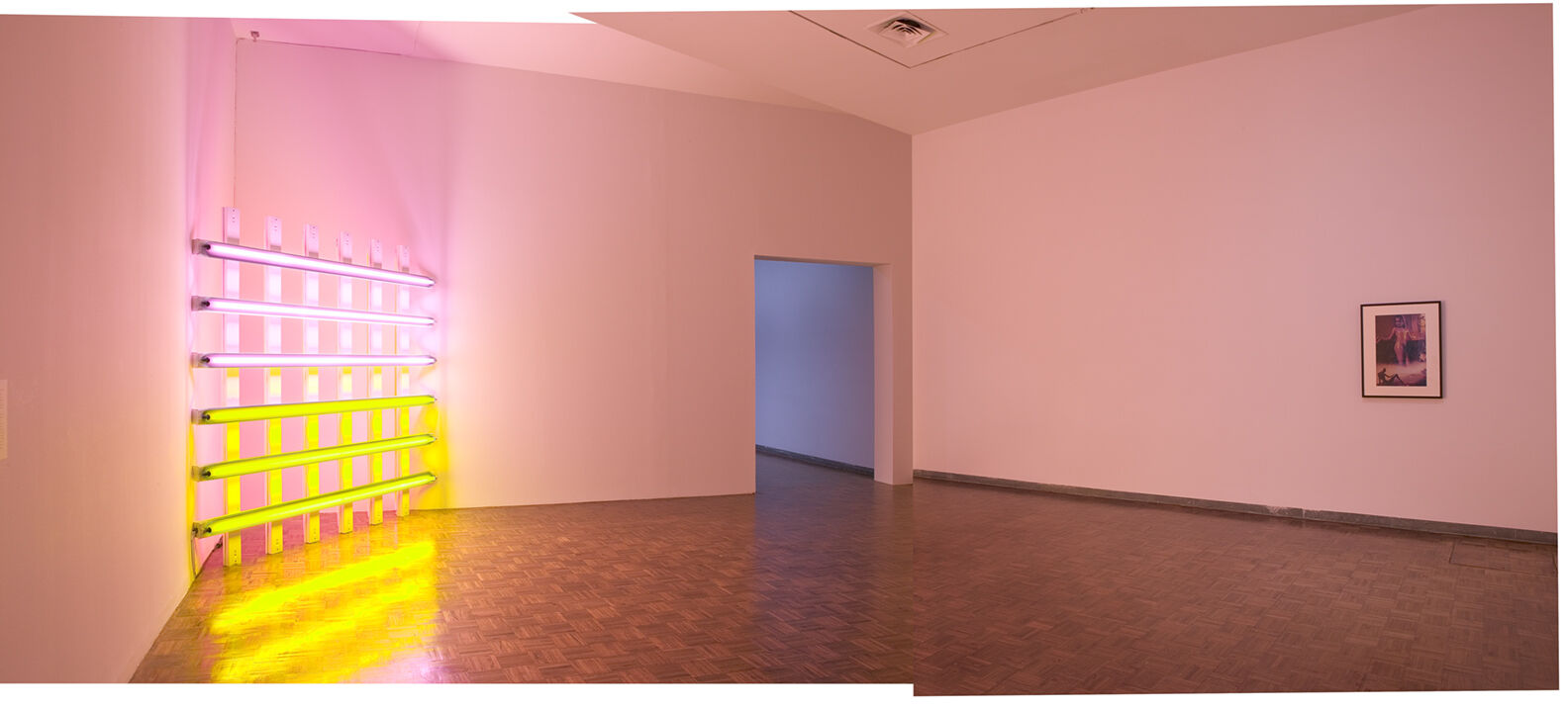 An installation with pink and yellow lighting displayed in a gallery.