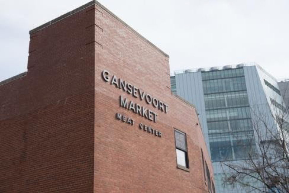 The top of a brick building with lettering that reads "Gansevoort Market Meat Center". 