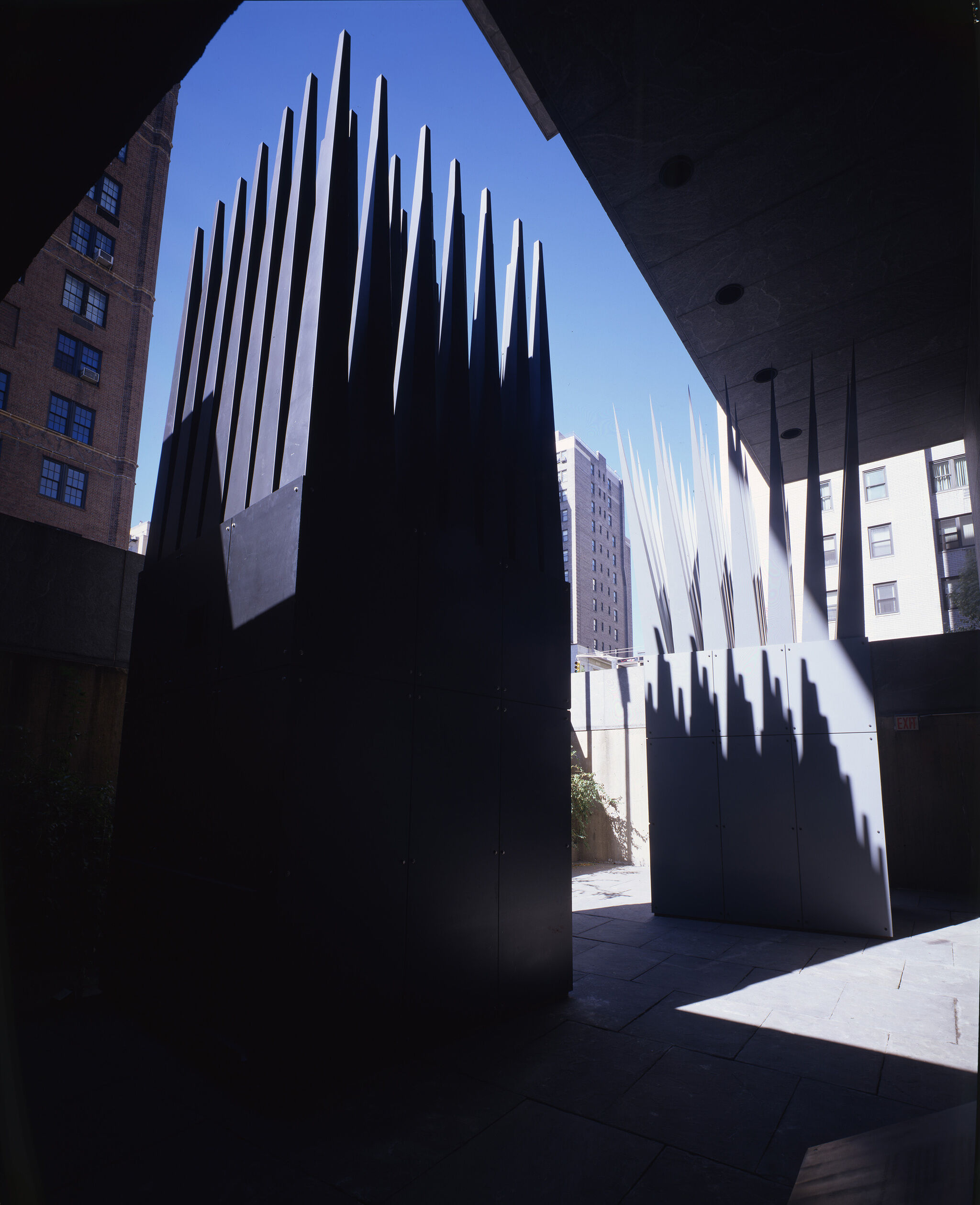 A sculpture with a rectangular base and long triangular parts pointing upwards.