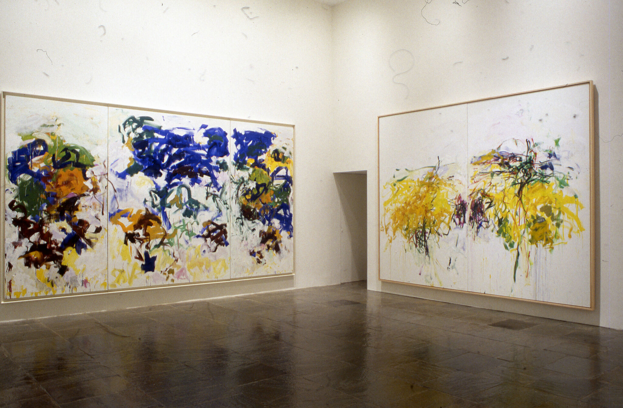 Two large abstract paintings displayed in a gallery.