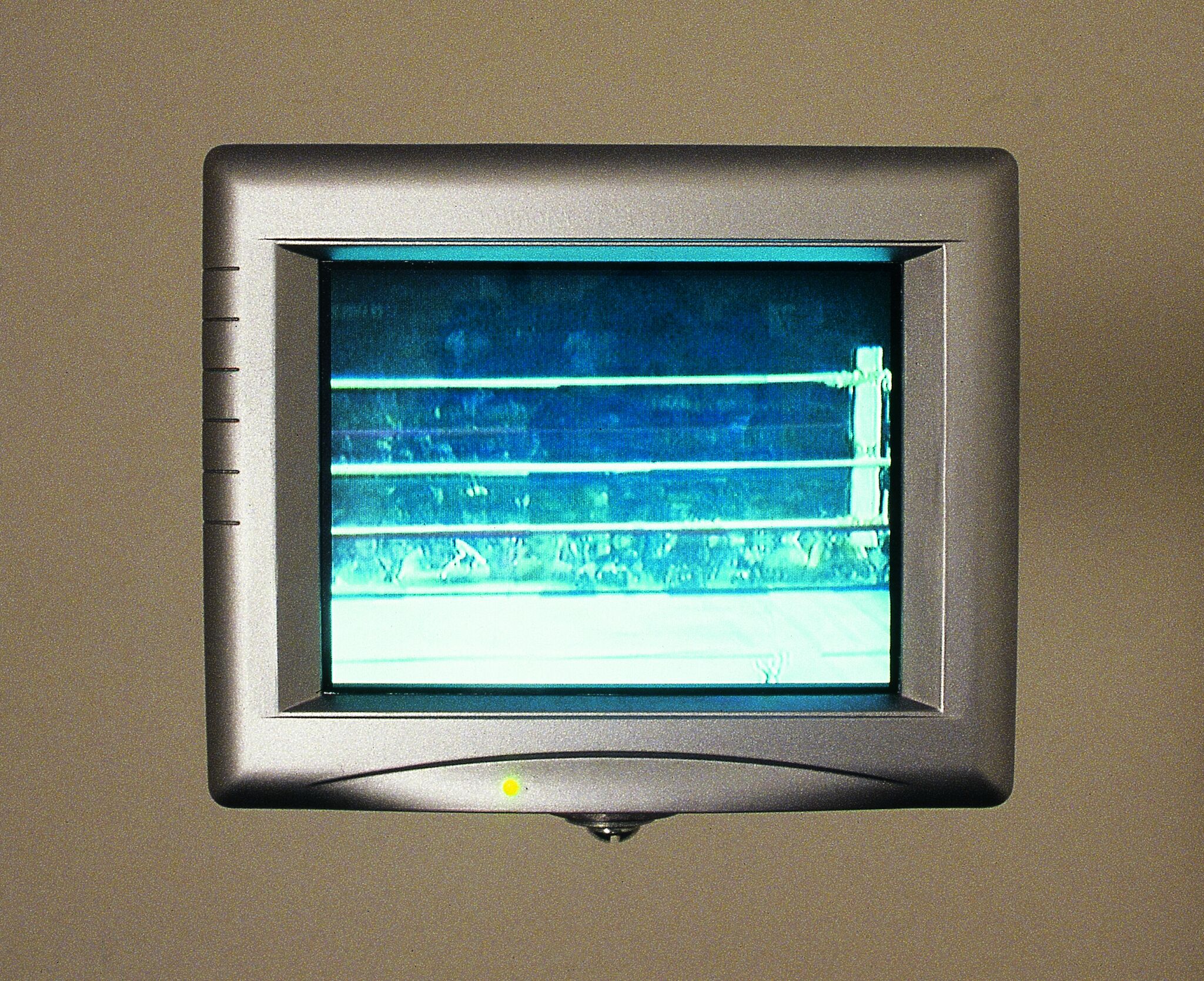 A monitor displaying a view of a wrestling ring.