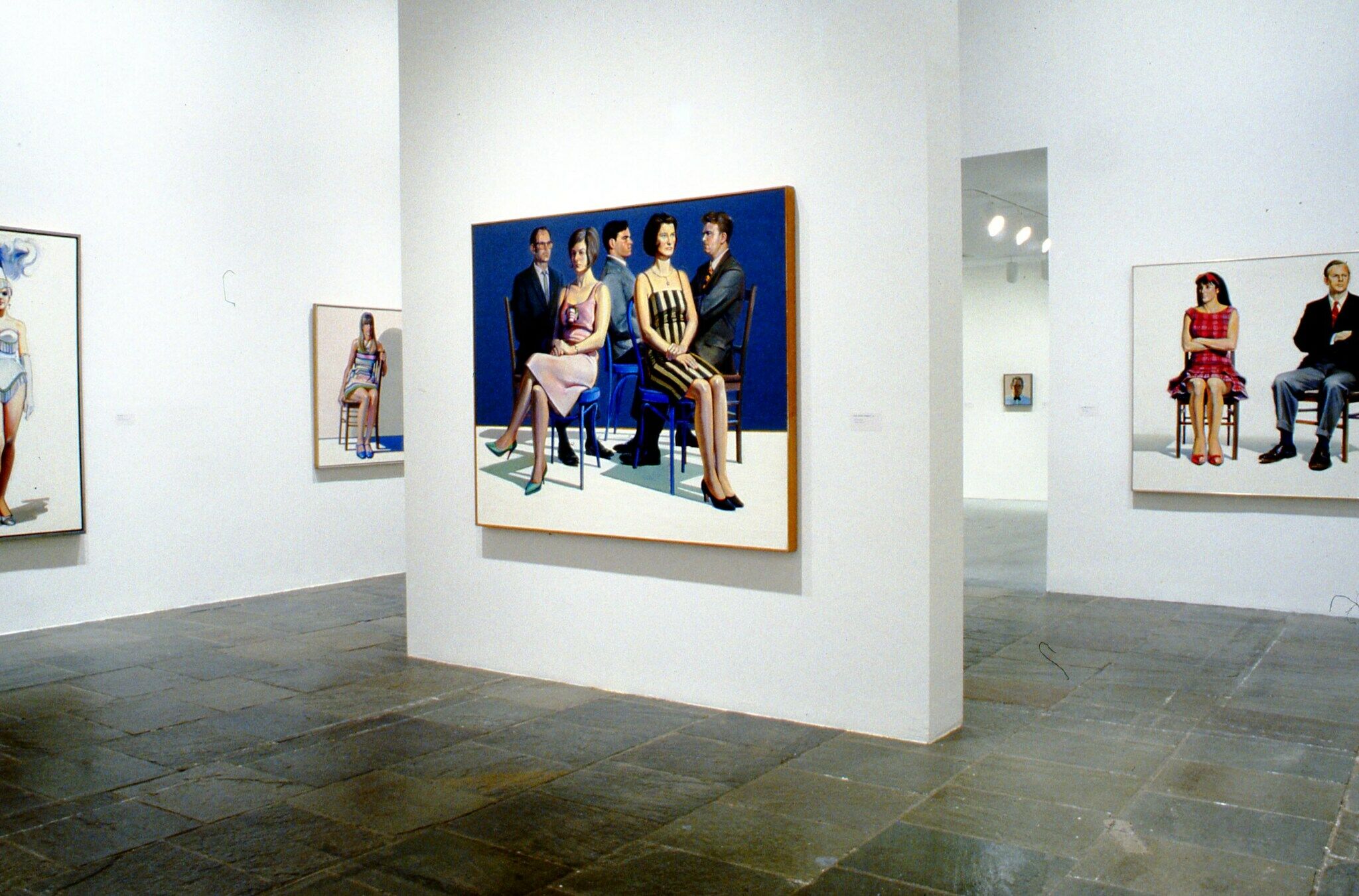 Paintings of figures displayed in a gallery.