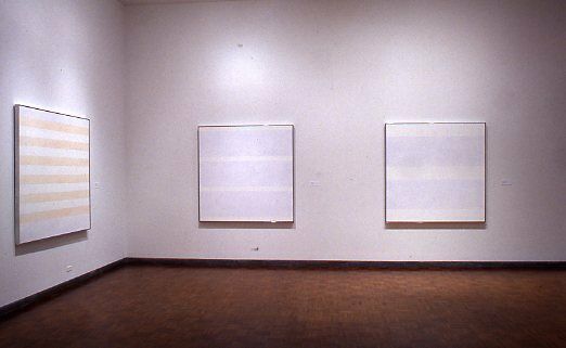 Three square abstract paintings depicting faint horizontal stripes.