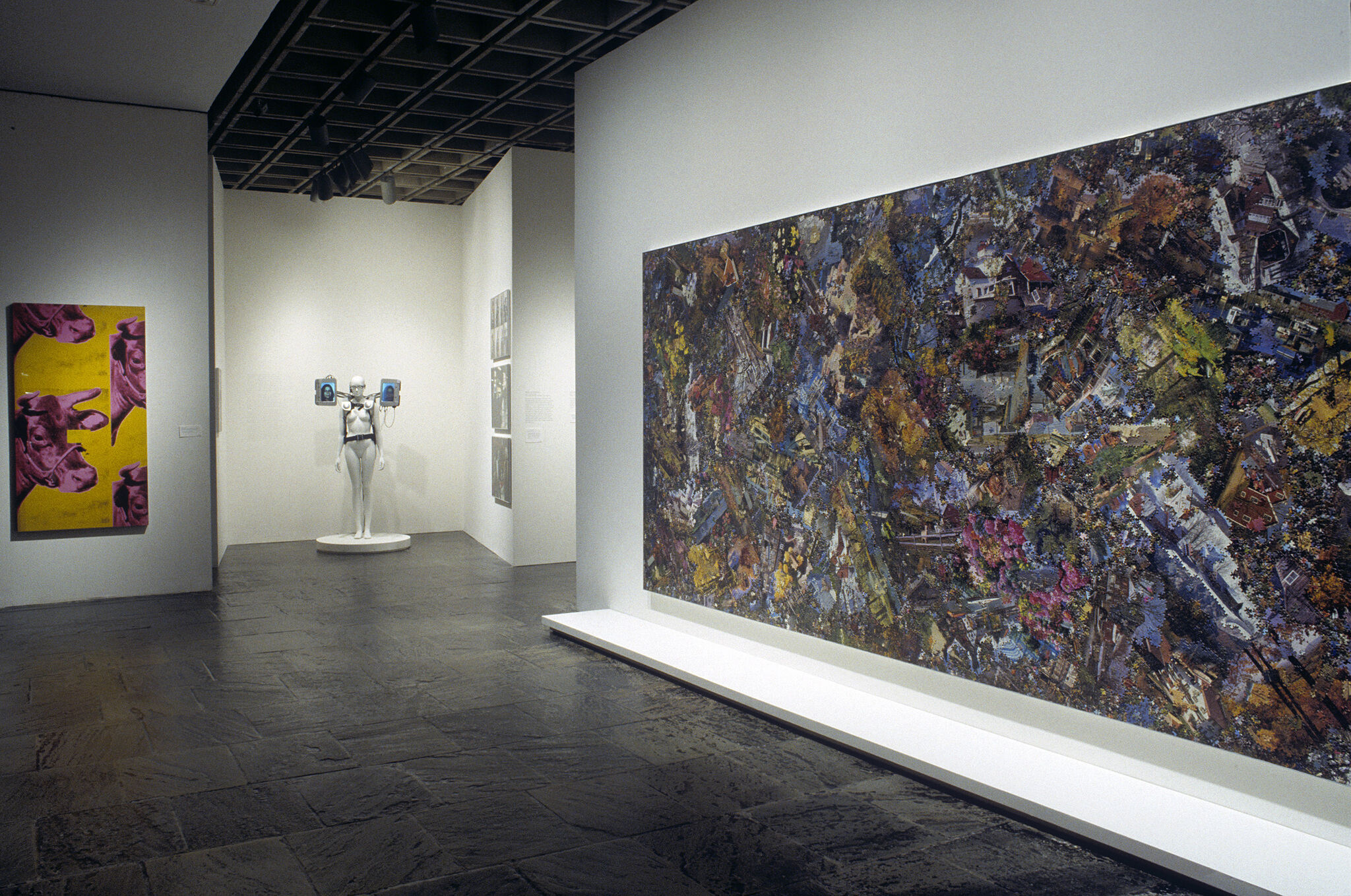 A gallery filled with works of art including paintings and a sculpture.