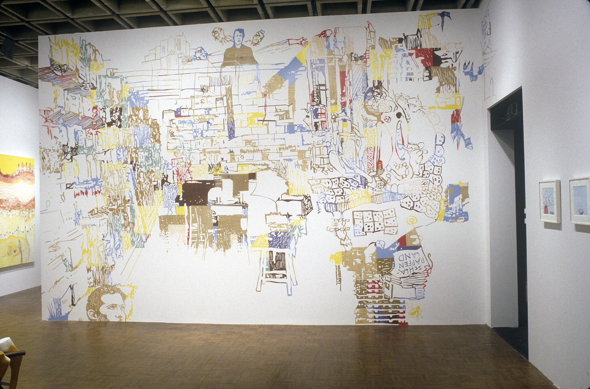 A wall in a gallery covered in a colorful wall drawing.
