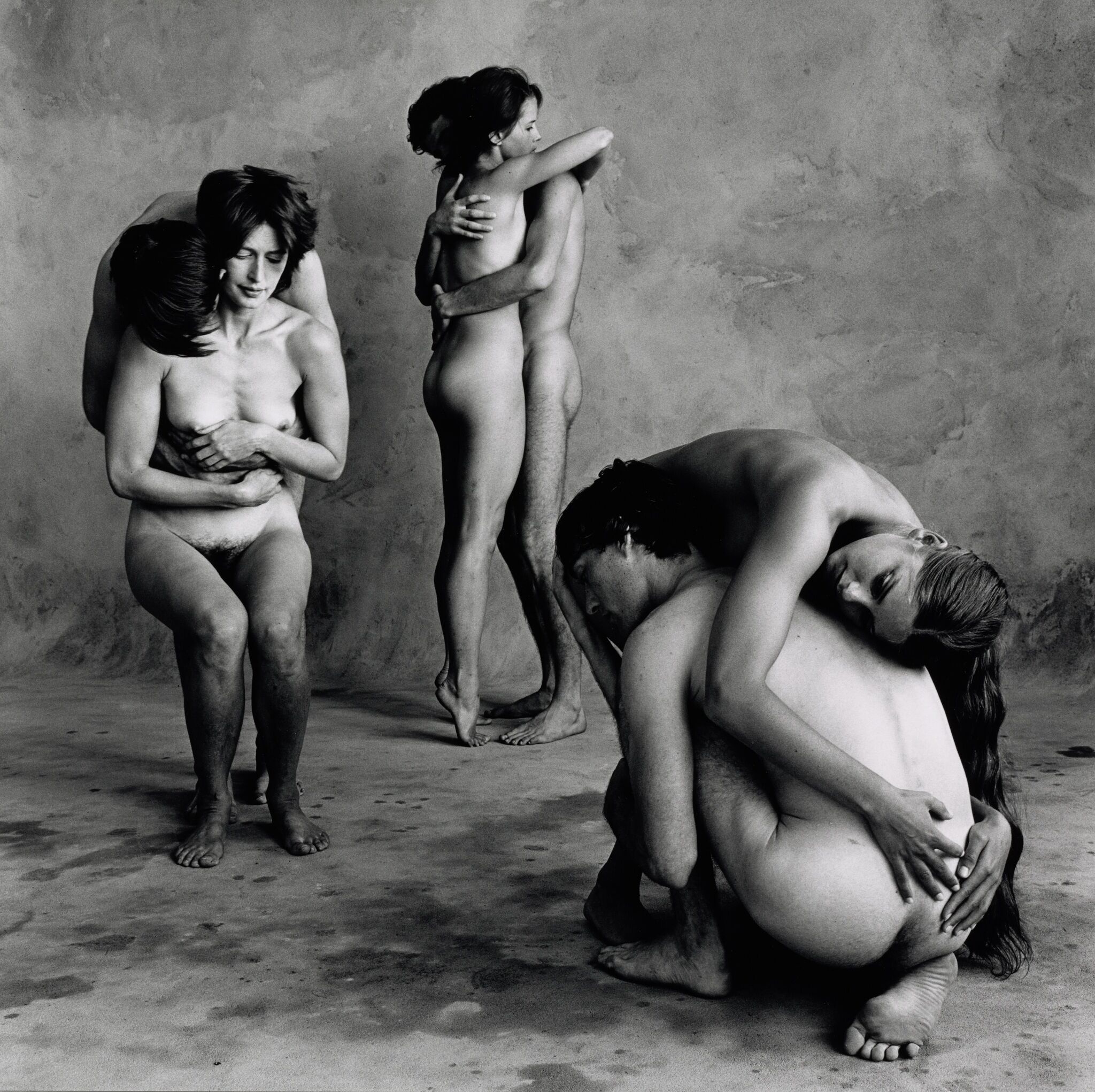 A grayscale image of three separate pairs of people embracing. 