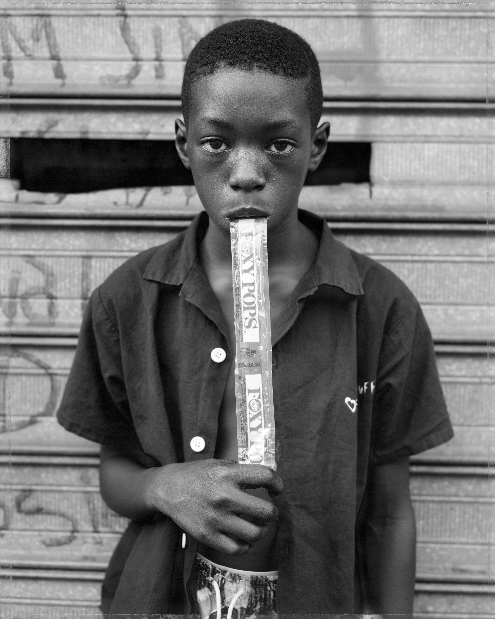 A portrait of a young boy eating an ice cream pop. 