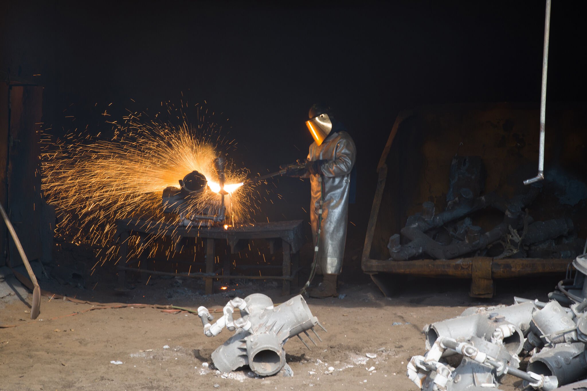 Metalworker welding with sparks flying.