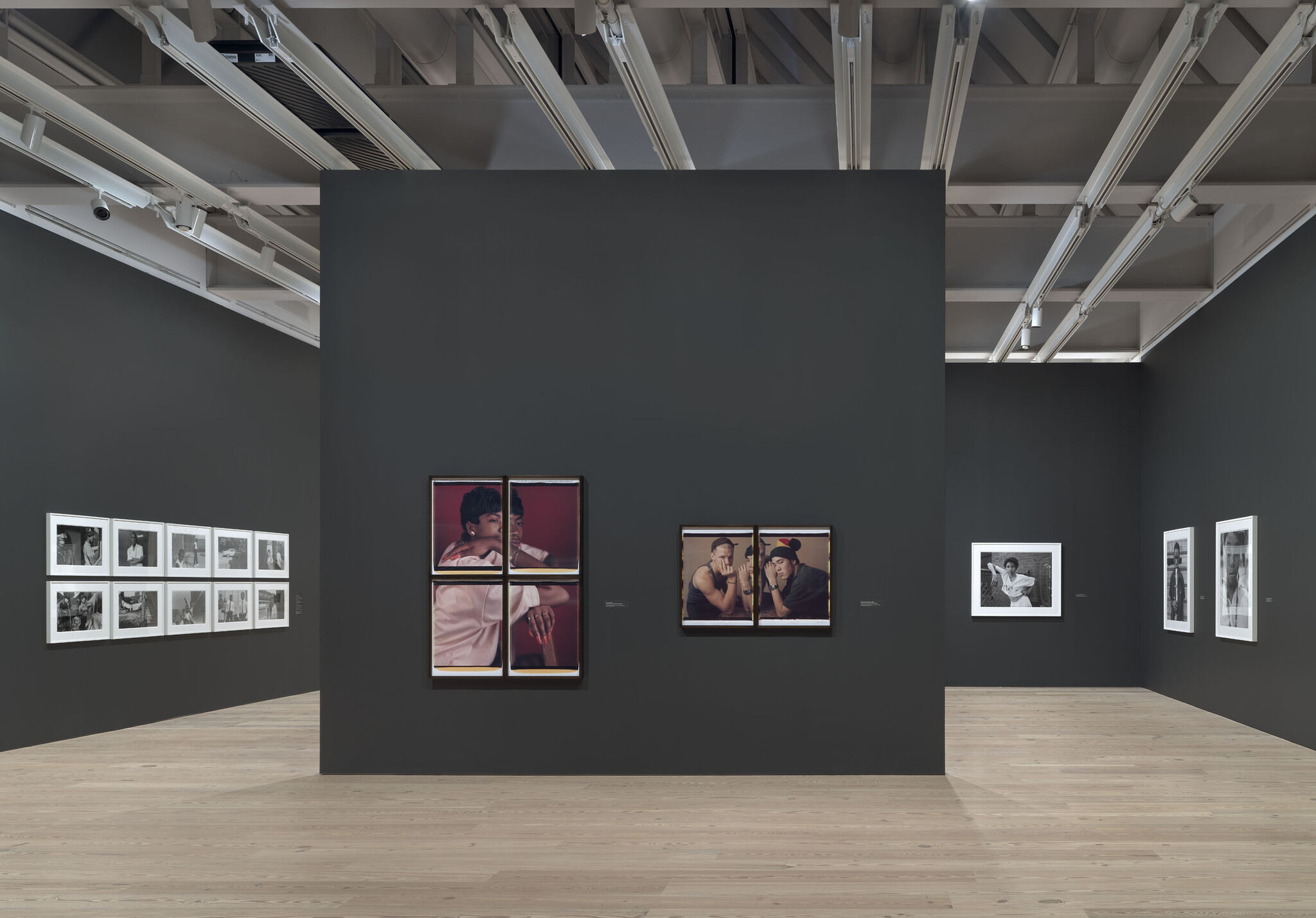 A main exhibition room of the Whitney with pieces mounted against black walls. 