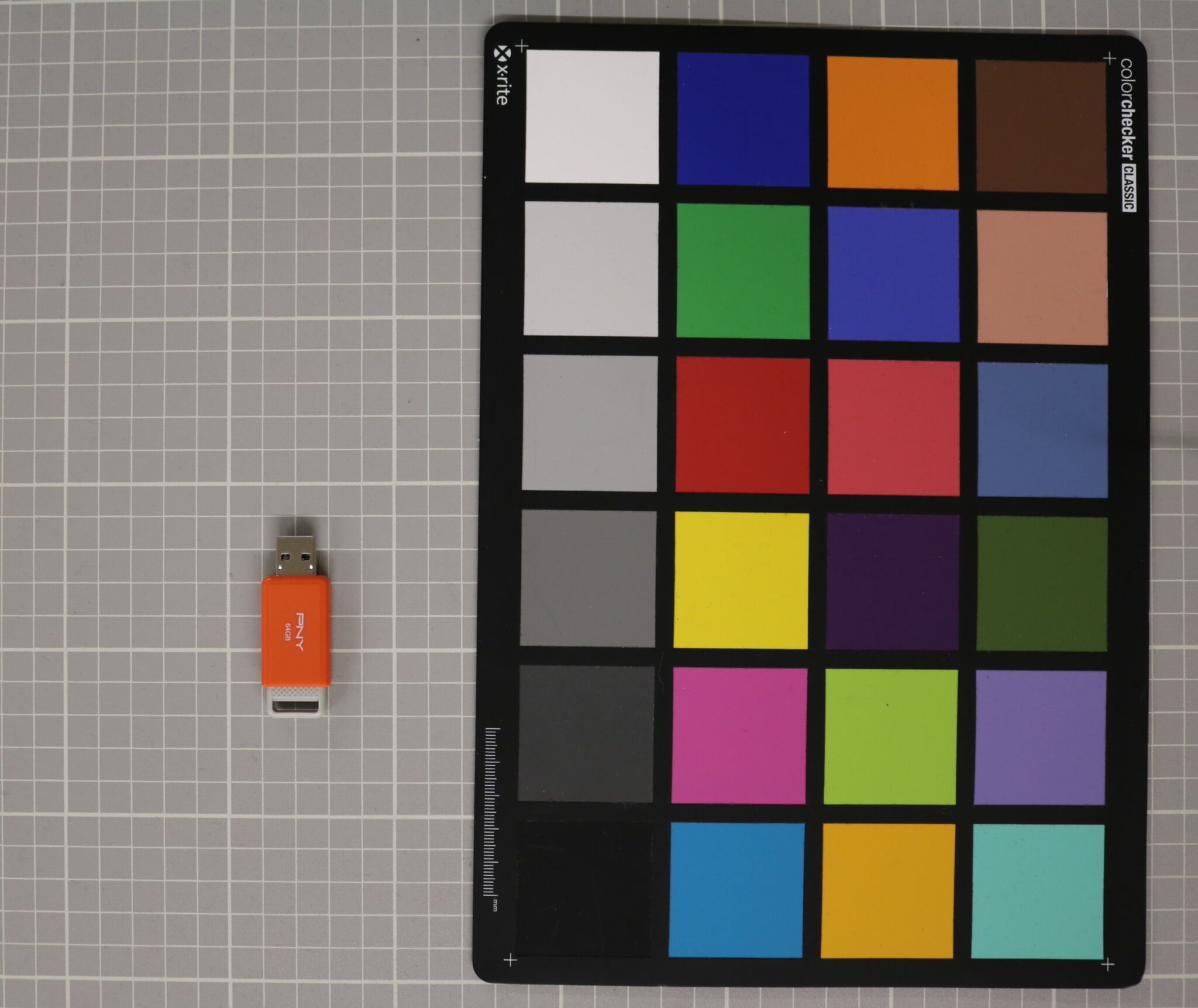 A flash drive and color reference tool placed next to each other on a table. 