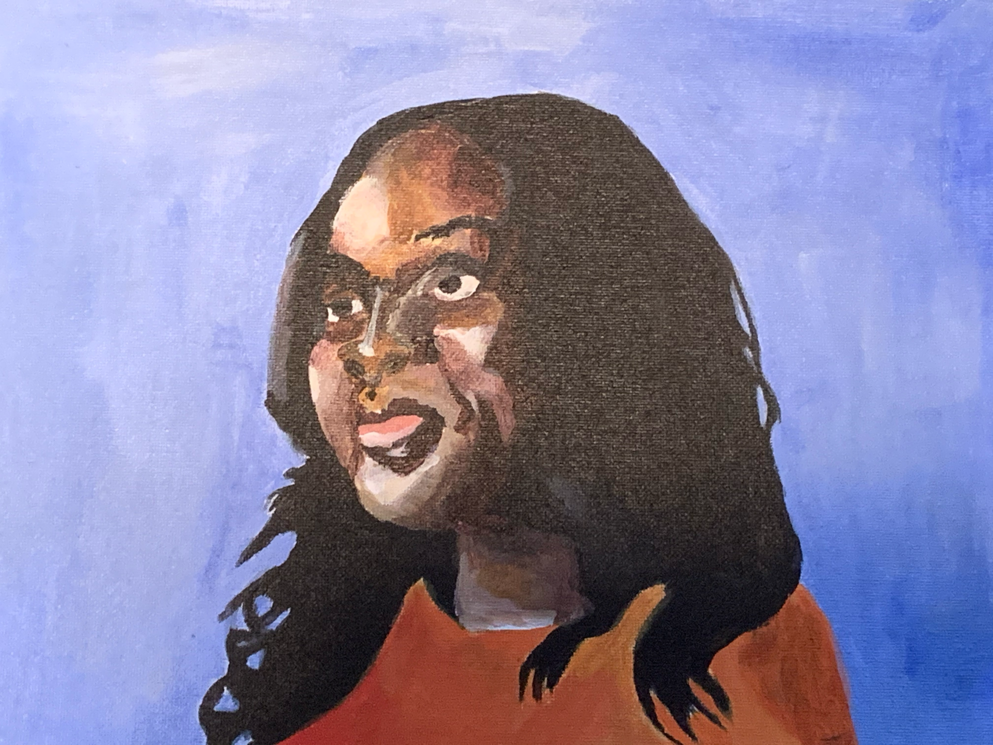 A portrait of Rhiana Gunn Wright against a blue backdrop. 