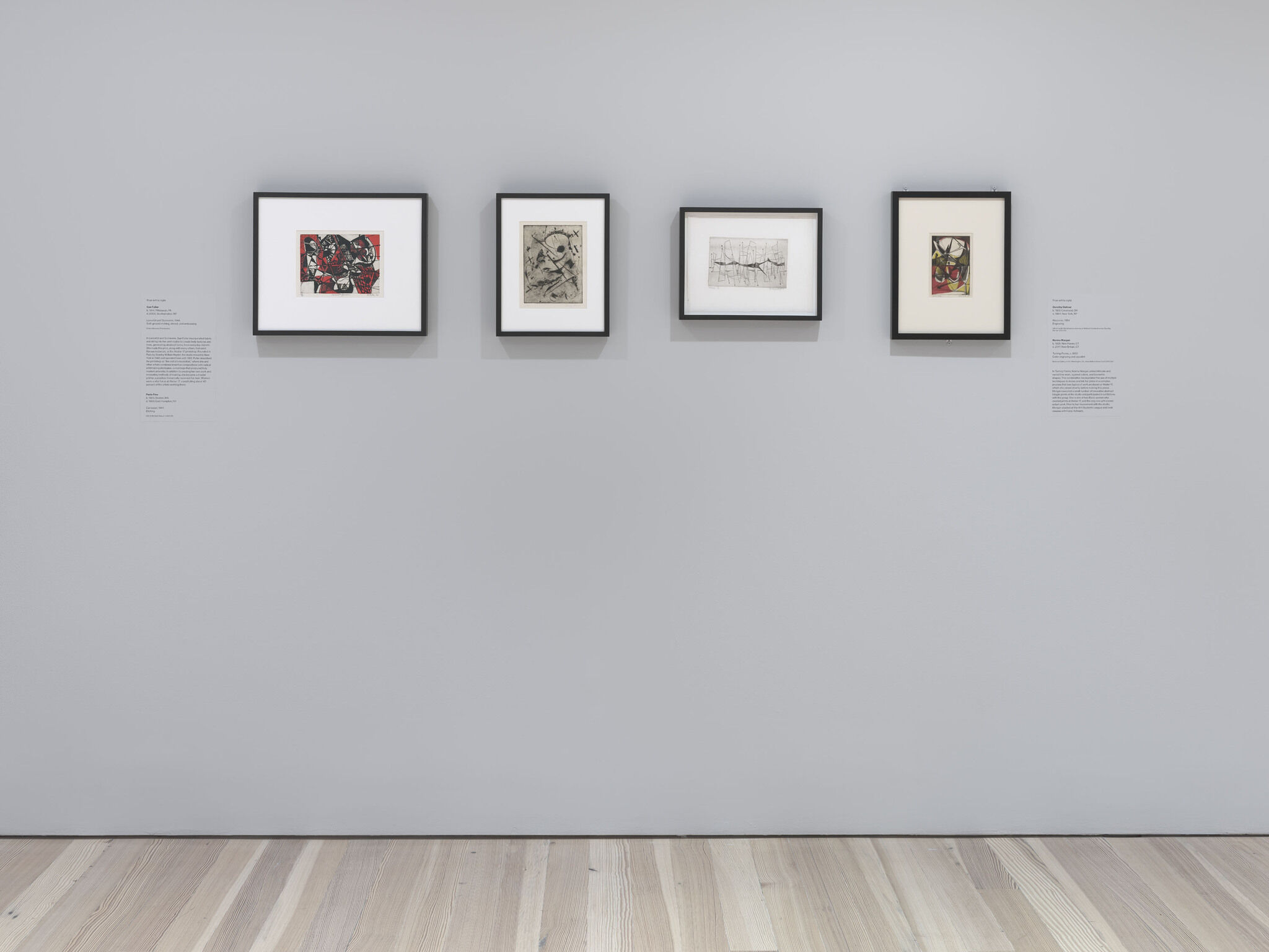 Four framed pieces are mounted on a white exhibition wall. 