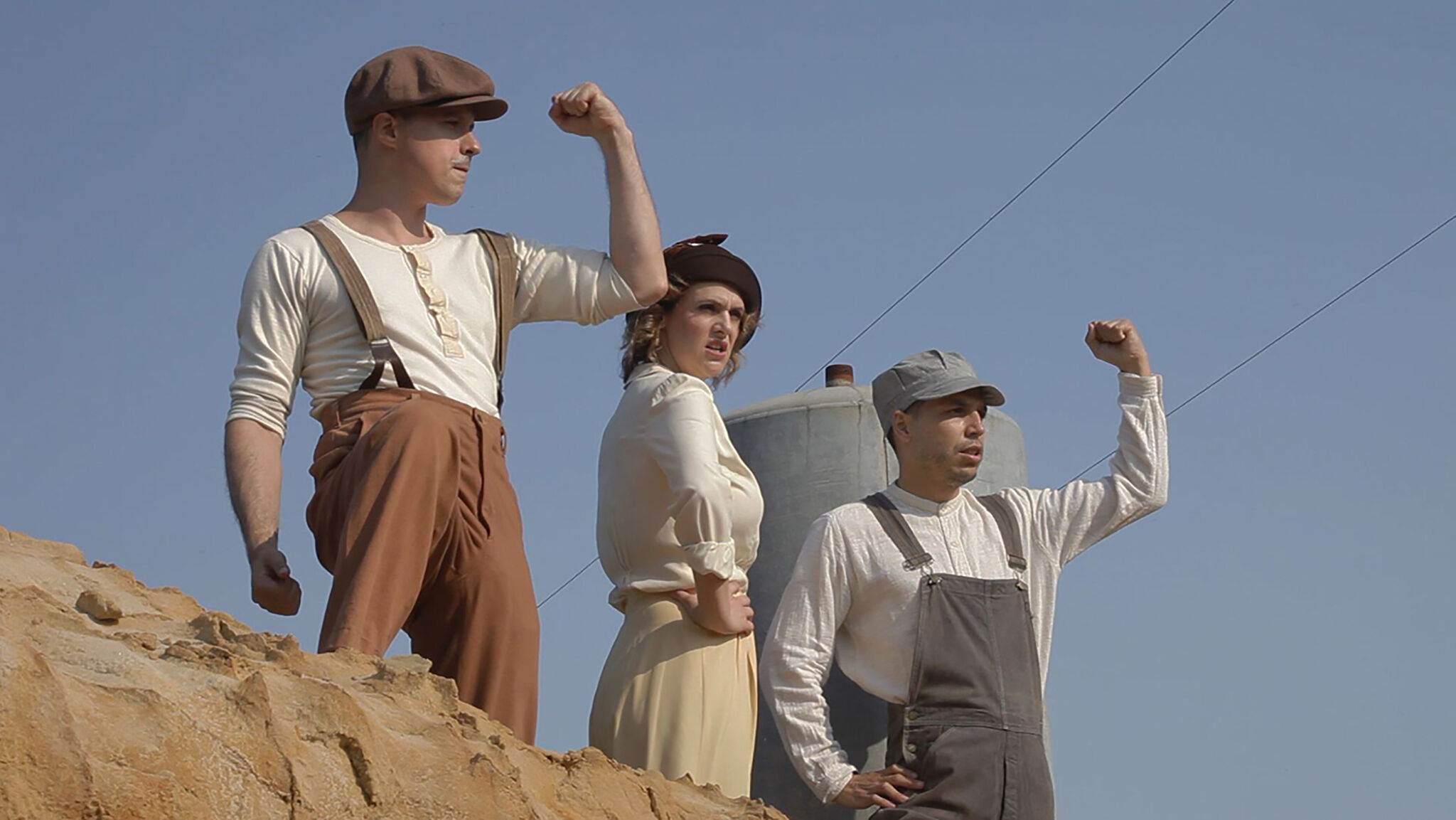 A young woman and two young men strike poses of youthful vigor in period attire