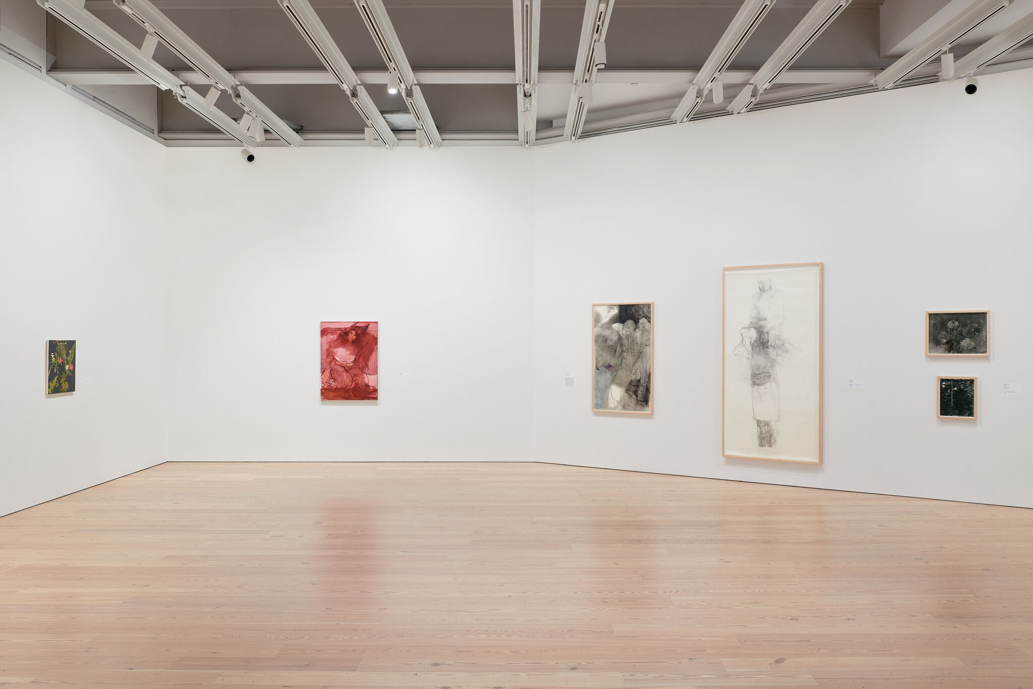 A white exhibition wall with six works mounted next to each other. 