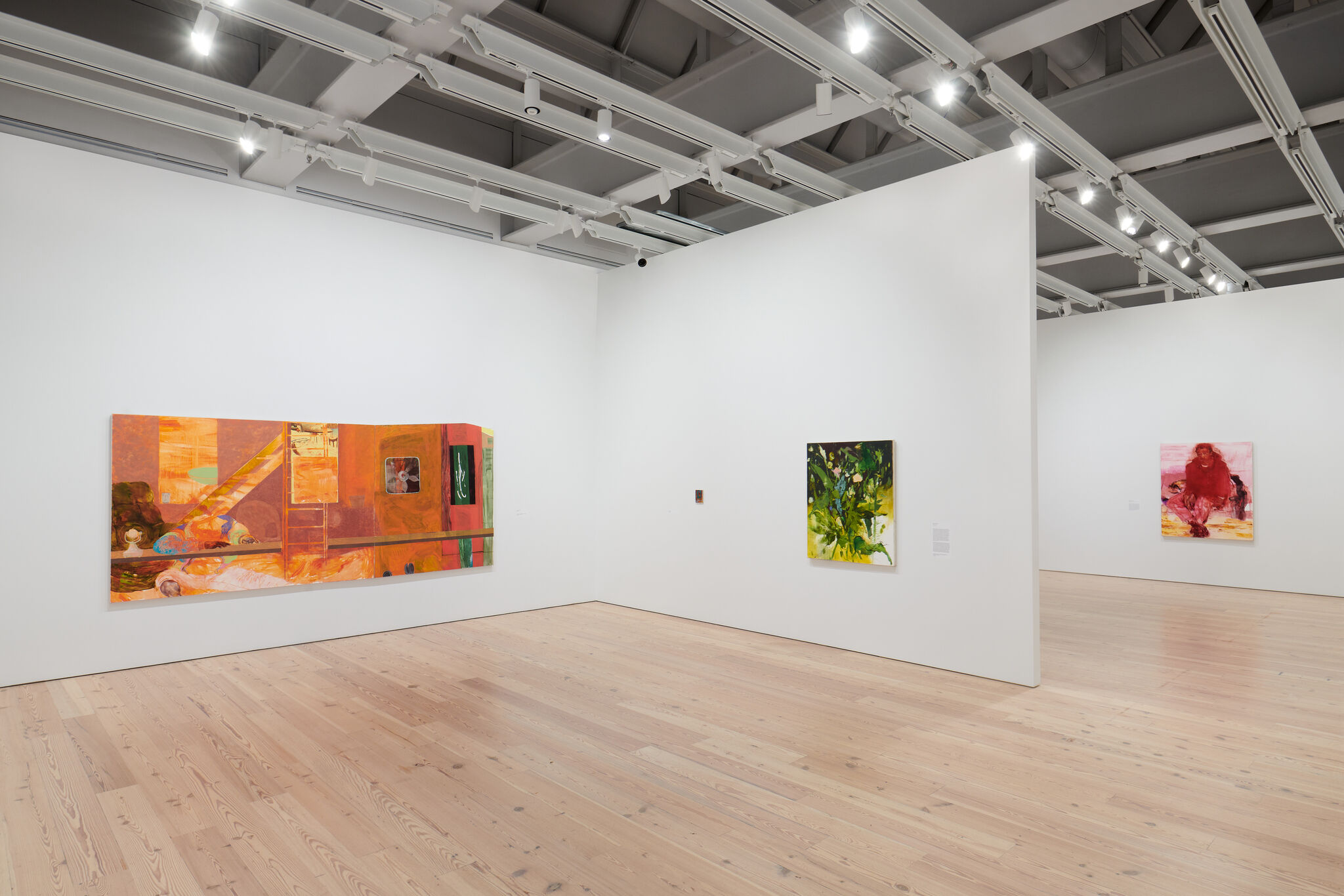 A white exhibition room with three works mounted across three separate walls. 