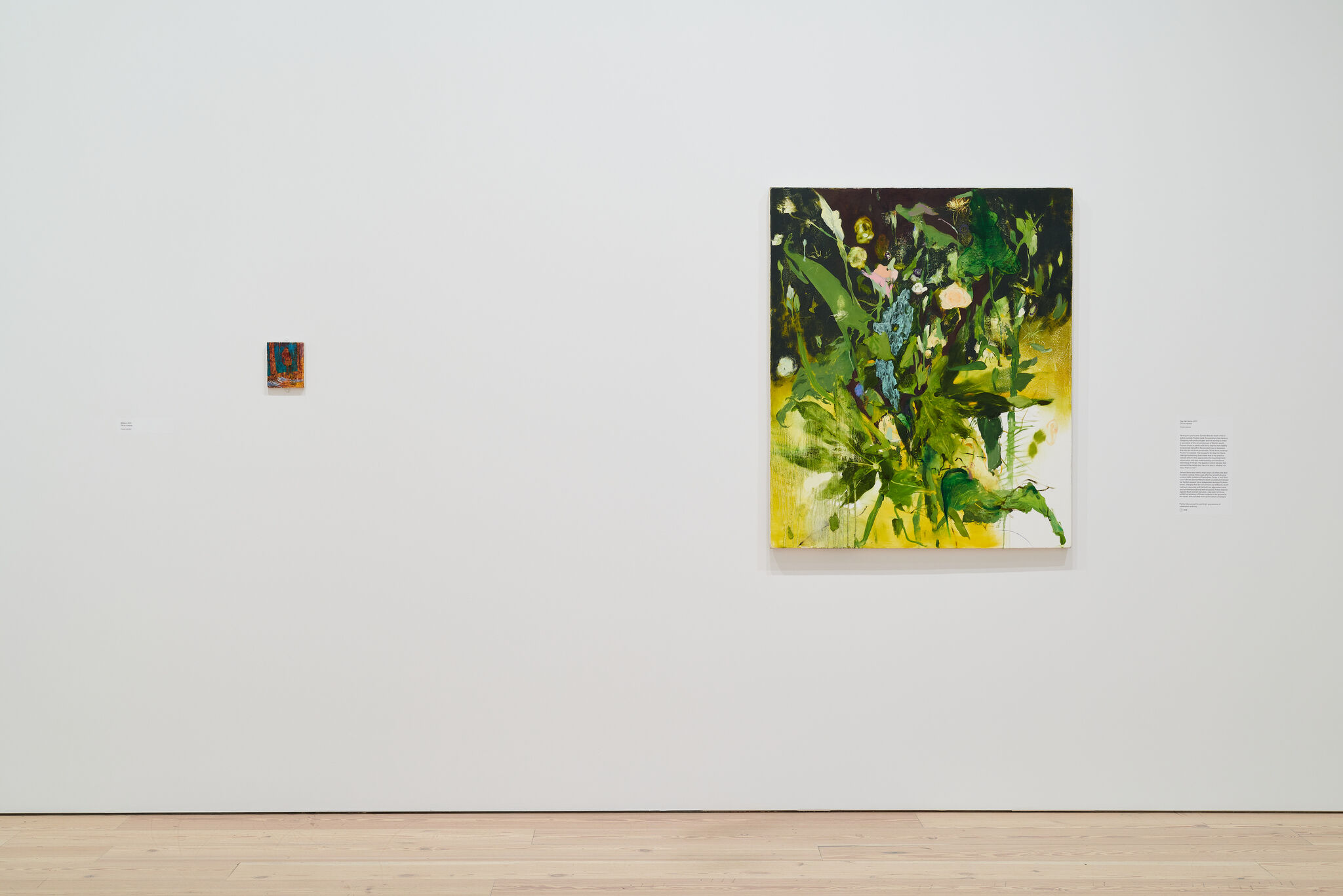 A white exhibition wall with two works mounted next to each other. 