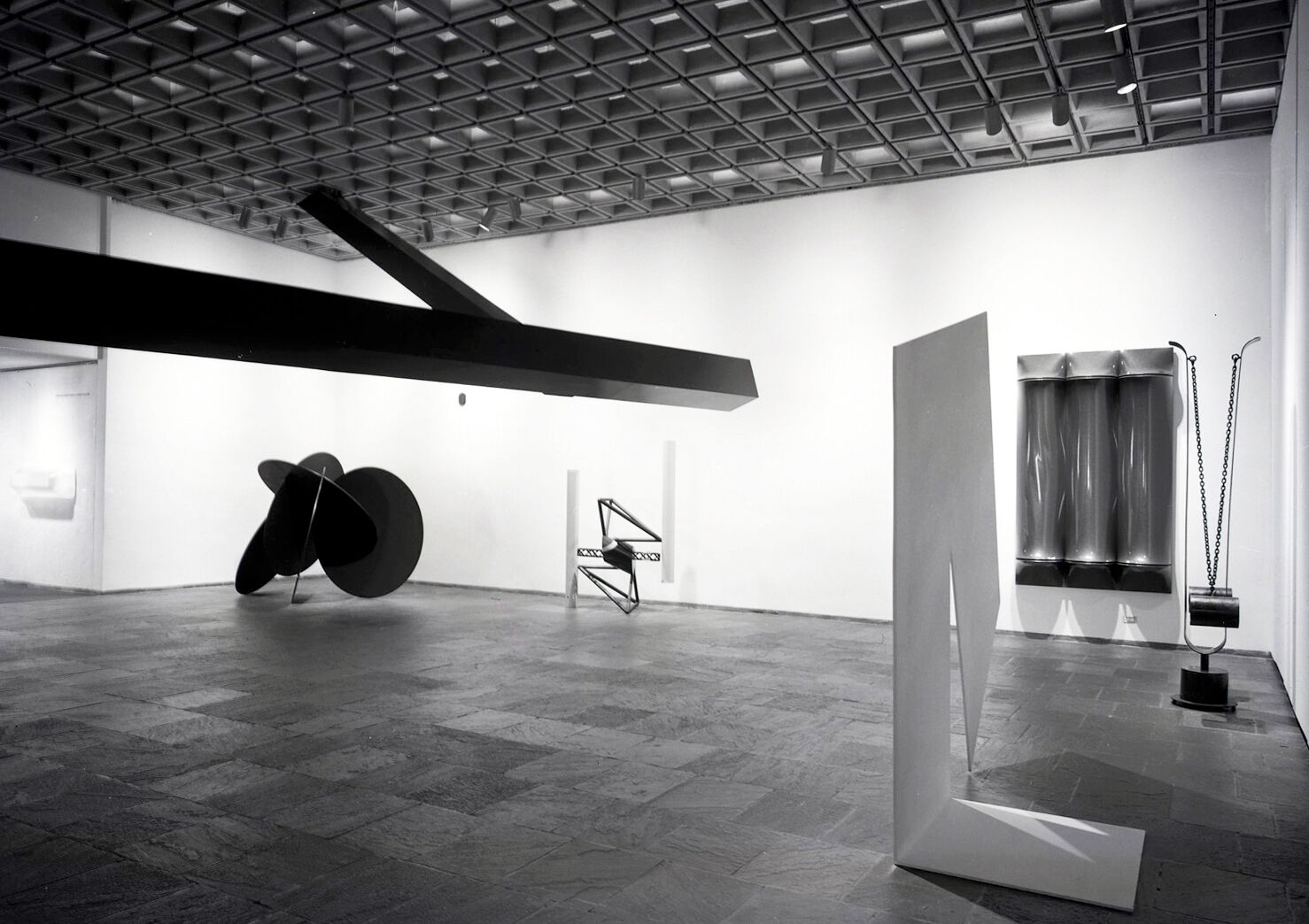 Black-and-white photograph of works of art in a gallery.