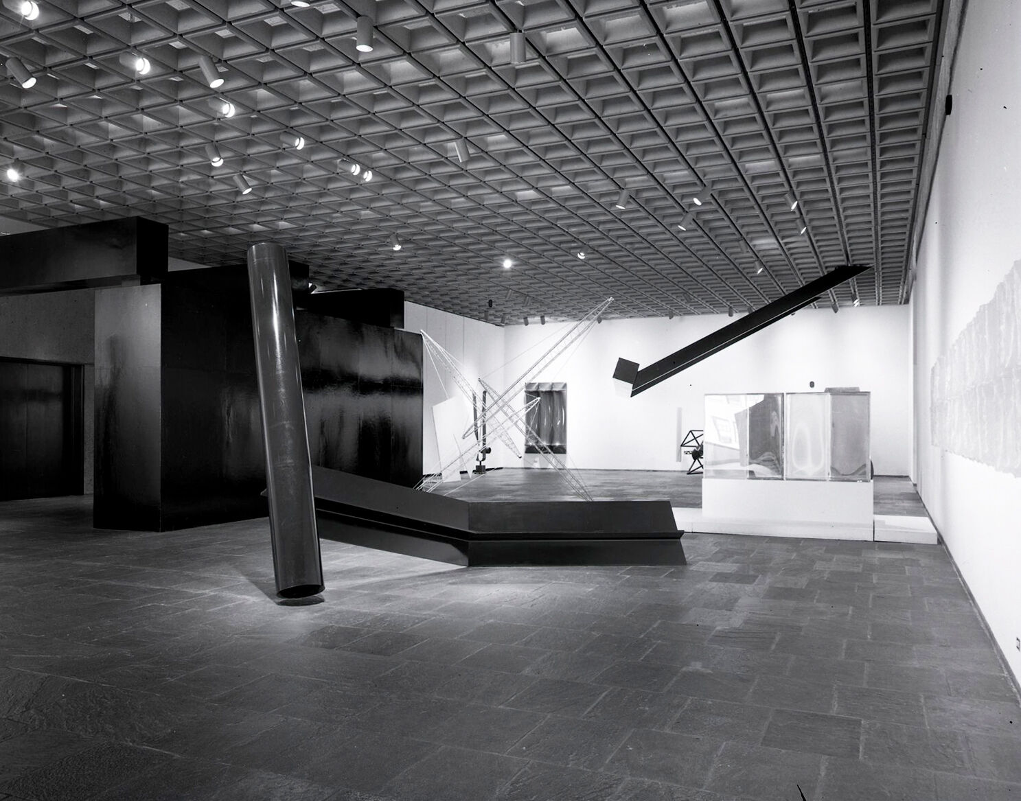 Black-and-white photograph of works of art in a gallery.