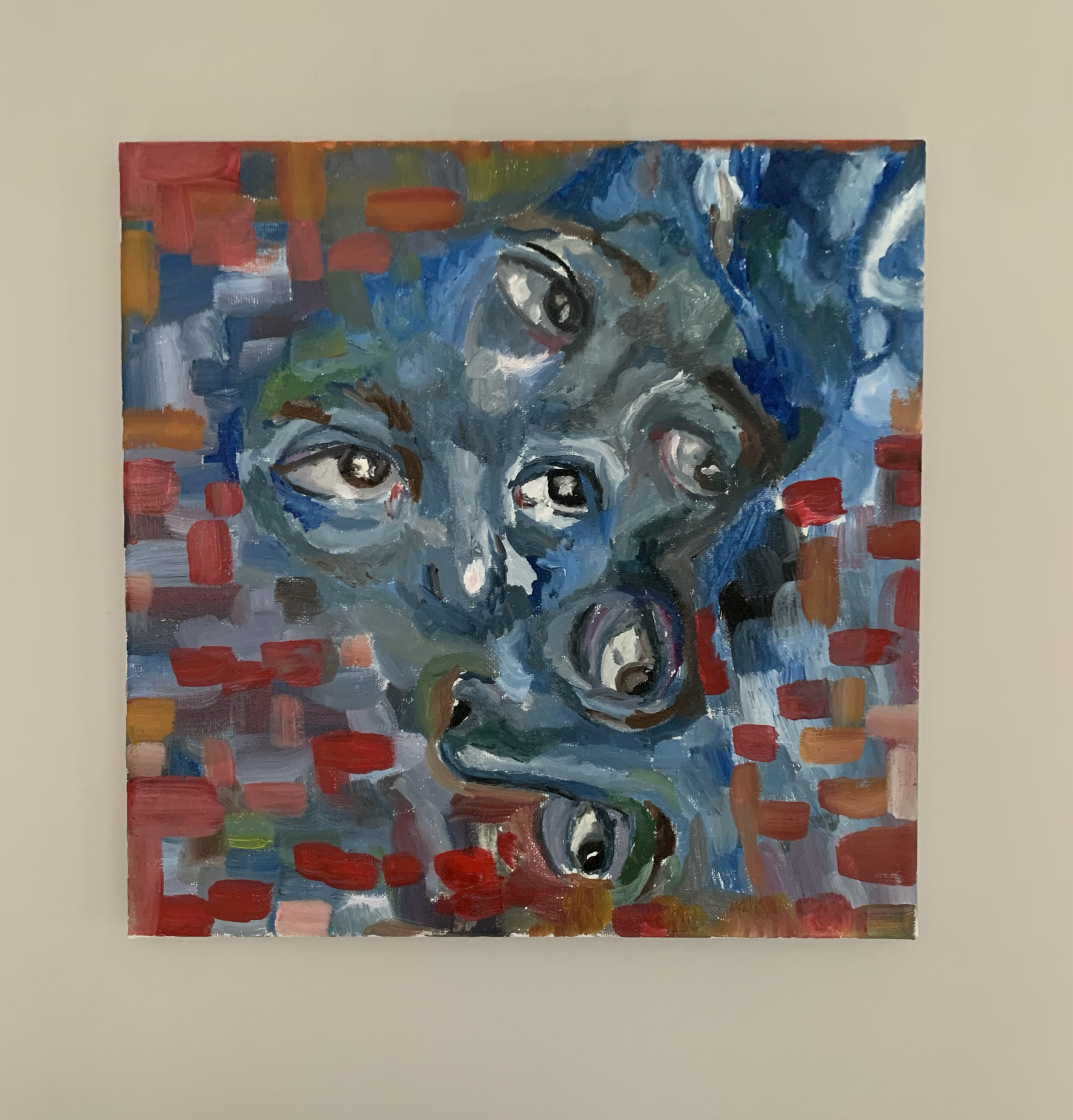 An abstract painting with a series of eyes painted at its center.  