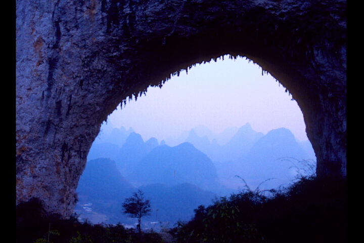 Blue mountains as seen through a natural archway.