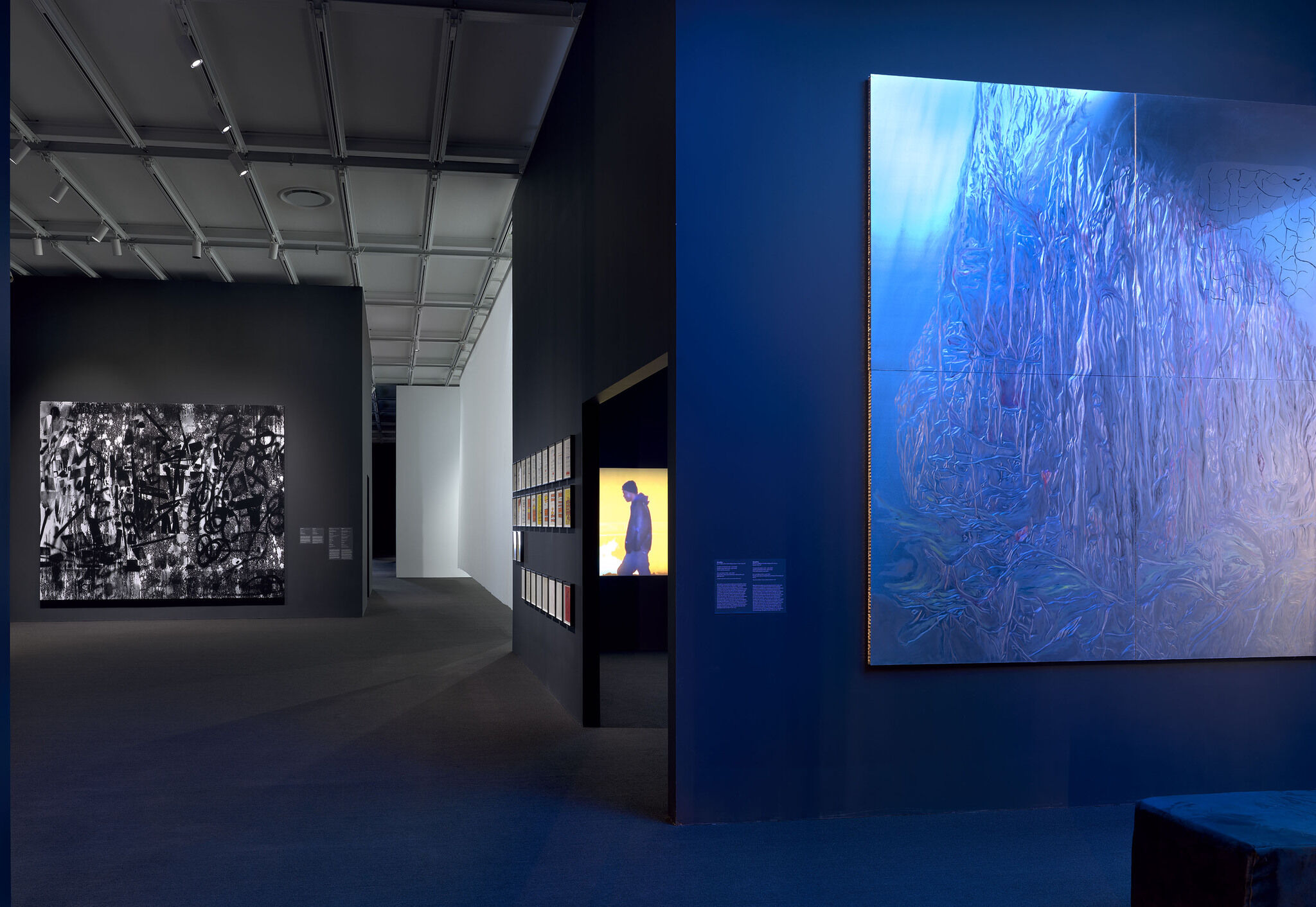 Dark gallery with multiple artworks.