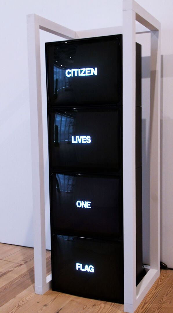 Four TVs stacked together within a white, shelf-like structure with one word displayed in the middle of each screen.